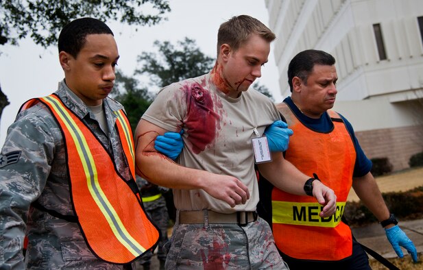 Emergency medical technicians from the 96th Medical Group move a wounded Airman toward safety during an active shooter exercise at Eglin Air Force Base, Fla., Feb. 4.  The active-shooter was the second of a series of 96th Test Wing exercises occurring all week.  (U.S. Air Force photo/Samuel King Jr.)