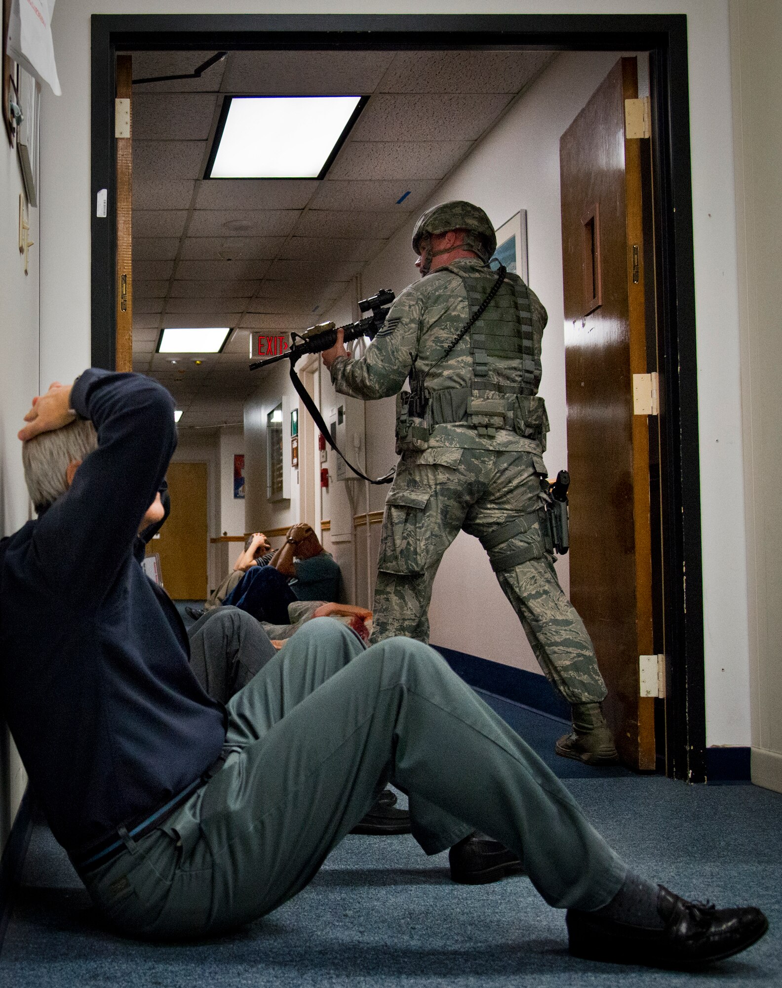 Civilians wait to be removed from the scene as 96th Security Forces Squadron personnel look for suspects during an active shooter exercise at Eglin Air Force Base, Fla., Feb. 4.  The active-shooter was the second of a series of 96th Test Wing exercises occurring all week.  (U.S. Air Force photo/Samuel King Jr.)