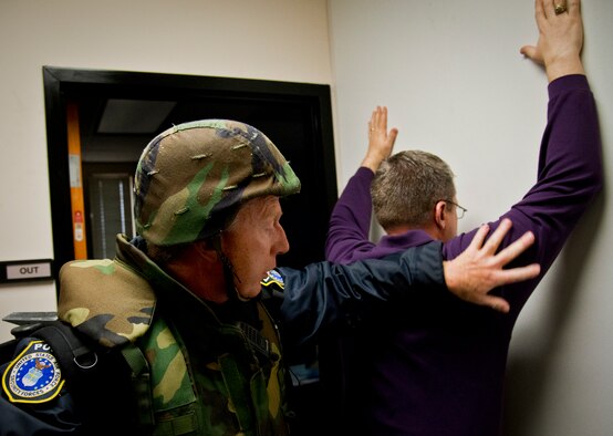A civilian guard checks a person for any weapons during the clearing stage of the active shooter exercise at Eglin Air Force Base, Fla., Feb. 4.  The active-shooter was the second of a series of 96th Test Wing exercises occurring all week.  (U.S. Air Force photo/Samuel King Jr.)