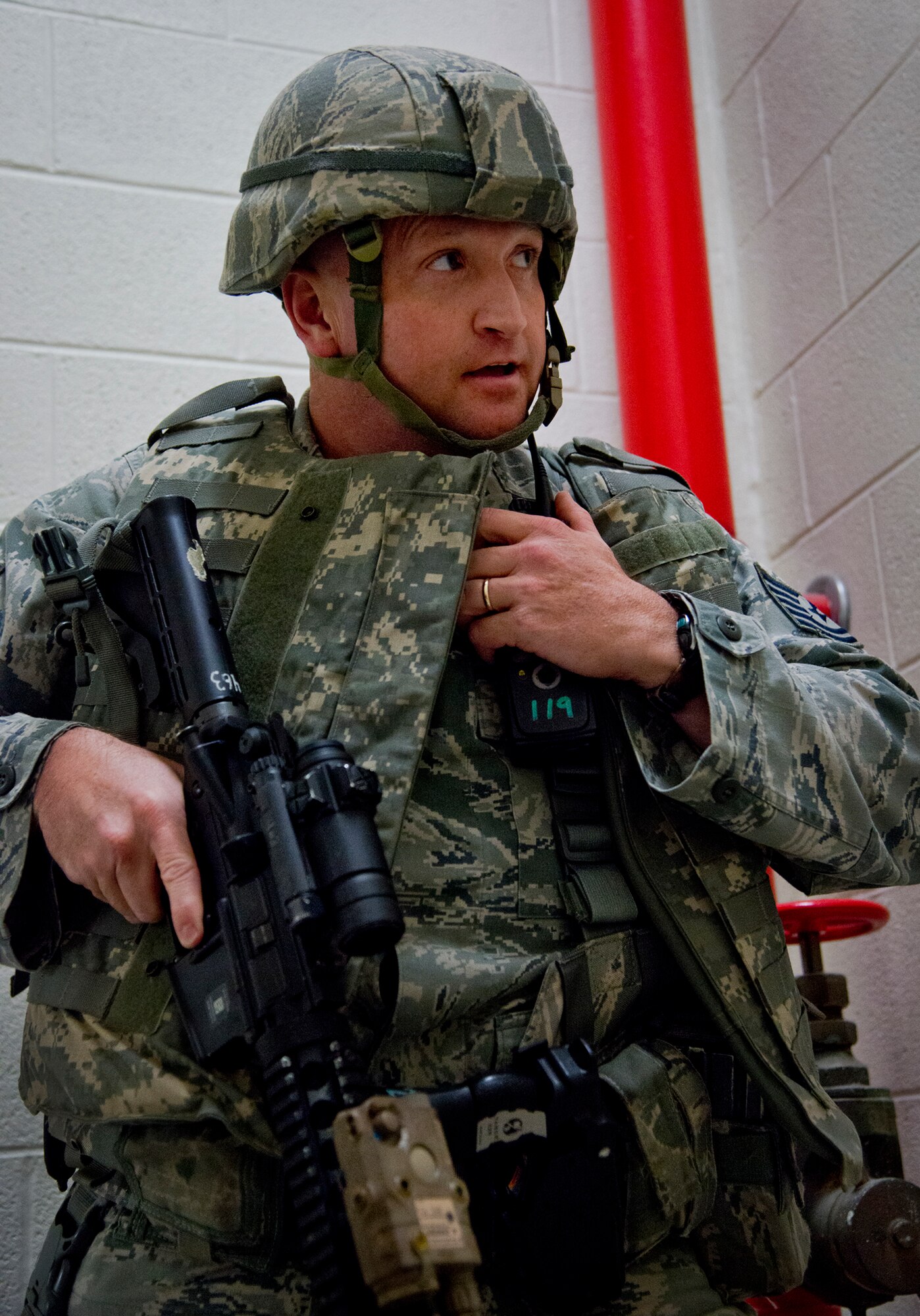Tech. Sgt. Enoch Williams, of the 96th Security Forces Squadron, communicates his findings upon reaching the floor where shots were fired during an active shooter exercise at Eglin Air Force Base, Fla., Feb. 4.  Williams was the first responder on scene and entered the building to assess the situation.  The active-shooter was the second of a series of 96th Test Wing exercises occurring all week.  (U.S. Air Force photo/Samuel King Jr.)
