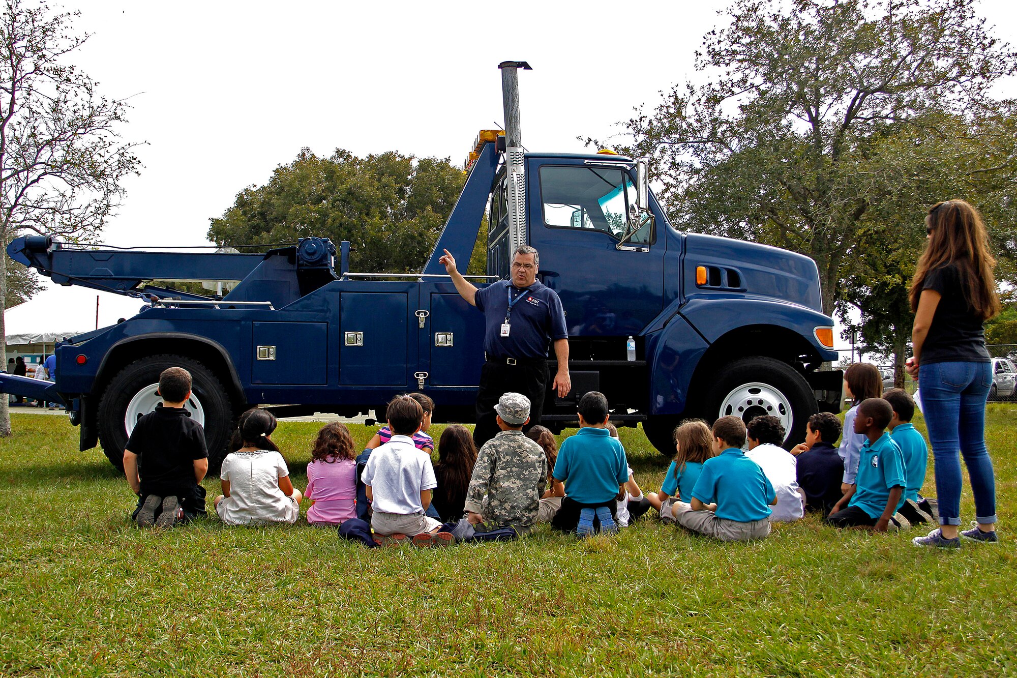 Michael Collins, transportation manager for Phoenix Management Inc., at Homestead Air Reserve Base, Fla., talks to students at Air Base K-8 Center in Homestead, Fla., about his job and the wrecker used as a static display for Truck Day on Jan. 31.  Truck Day is a way for the school to teach children about different careers available to them when they leave school so they can start thinking about what they want to do when they grow up. (U.S. Air Force photo by Senior Airman Jaimi L. Upthegrove)