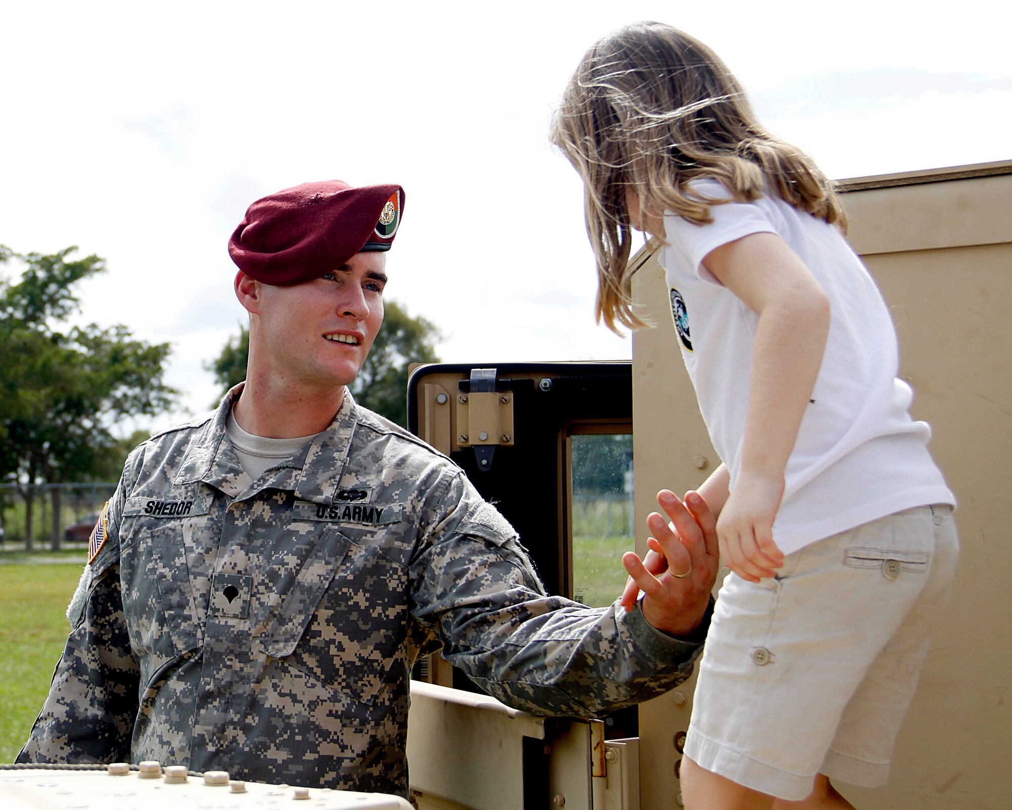U.S Army Spc. Chase A. Shedor, a satellite systems operator and maintainer for the 112th Signal Detachment at Special Operations Command South, helps a student at Air Base K-8 Center in Homestead, Fla., get down from a HMMWV that SOCSOUTH brought out as a static display for the children in support of Truck Day on Jan. 31. Truck Day is a way for the school to teach children about different careers available to them when they leave school so they can start thinking about what they want to do when they grow up. (U.S. Air Force photo by Senior Airman Jaimi L. Upthegrove)