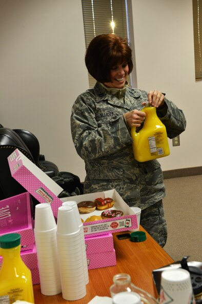 U.S. Air Force Capt. Mitzi Elliot, 20th Aerospace Medical Squadron public health officer, opens a bottle of orange juice during a morning gathering of coffee and doughnuts at Shaw Air Force Base, S.C. Jan. 31, 2014. The officers were taking part in the Biomedical Sciences Corps appreciation week which included a morning of free coffee, doughnuts and orange juice. (U.S. Air Force photo by Airman 1st Class Jensen Stidham/Released)