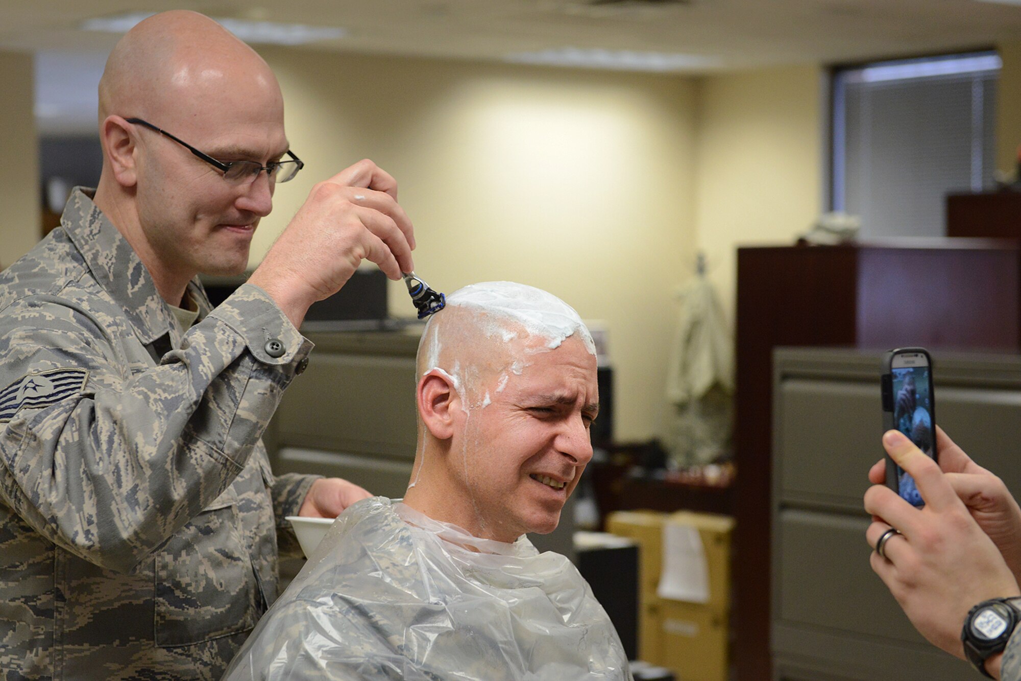Chief Master Sergeant Dennis Dipiazzo, Chief of Cyber Communications, 138th Communication Flight, Tulsa Air National Guard, gets  his head shaved by Technical Sergeant Michael Sauter, Sunday, Feb. 2, 2014.    CMSgt Dipiazzo, challenged Comm Flight personnel to acquire 100% organizational membership in the National Guard Association of Oklahoma, if they could,  he would allow them to shave his head.  They accomplished the task in less than 48 hours.  ( U.S. National Guard photo by Senior Master Sgt.  Preston L. Chasteen/Released)