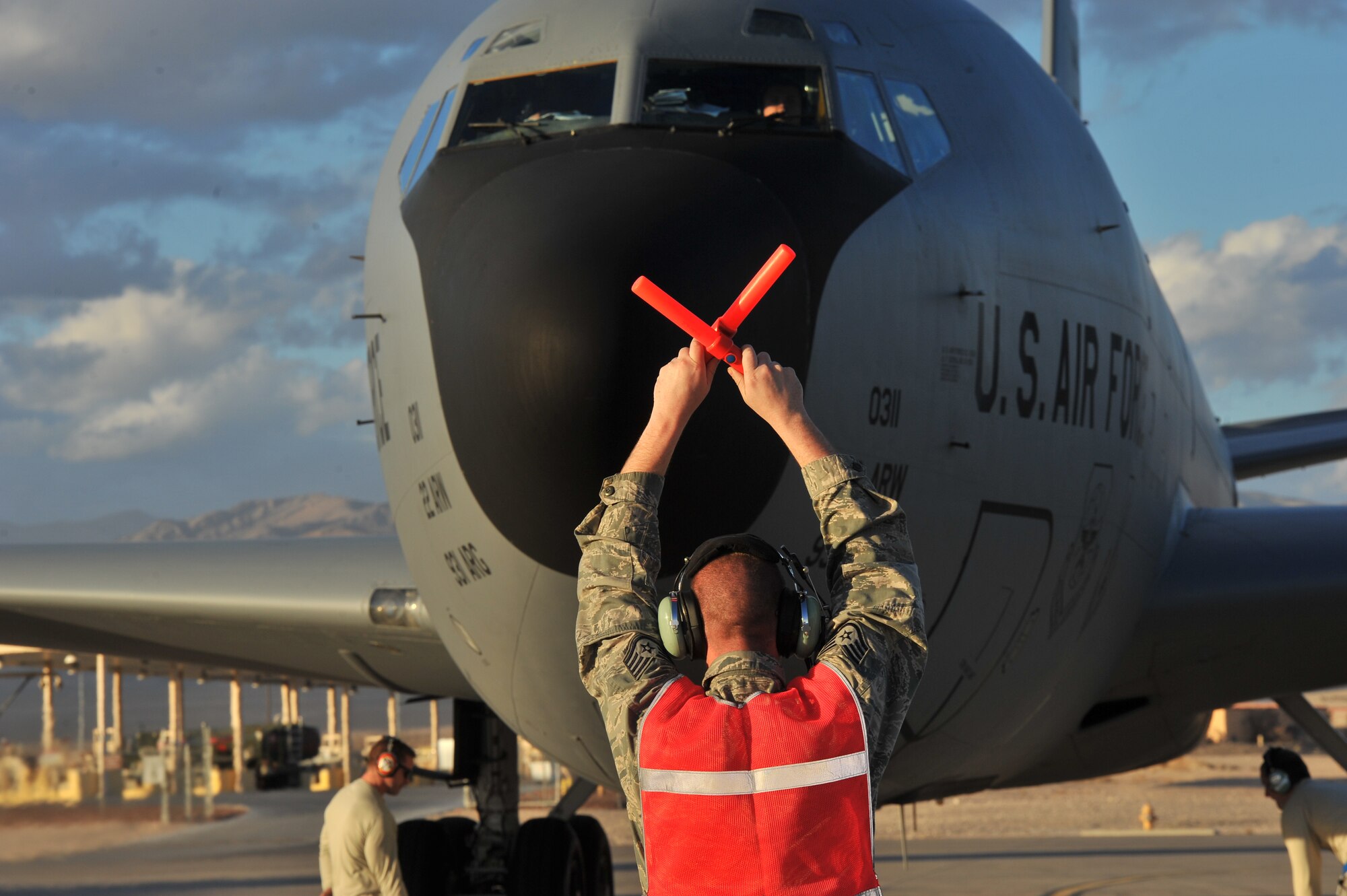 Staff Sgt. David Hendrickson, 92nd Aircraft Maintenance Squadron electronics and environmental journeyman, halts a KC-135 Stratotanker from Fairchild Air Force Base, Wash., after it landed at Nellis AFB, Nev., during Red Flag 14-1 Jan. 30, 2014. Red Flag is a realistic combat training exercise that incorporates air, space and cyber forces as part of the blue forces and their adversaries, the red forces. (U.S. Air Force photo by Staff Sgt. Veronica Montes)