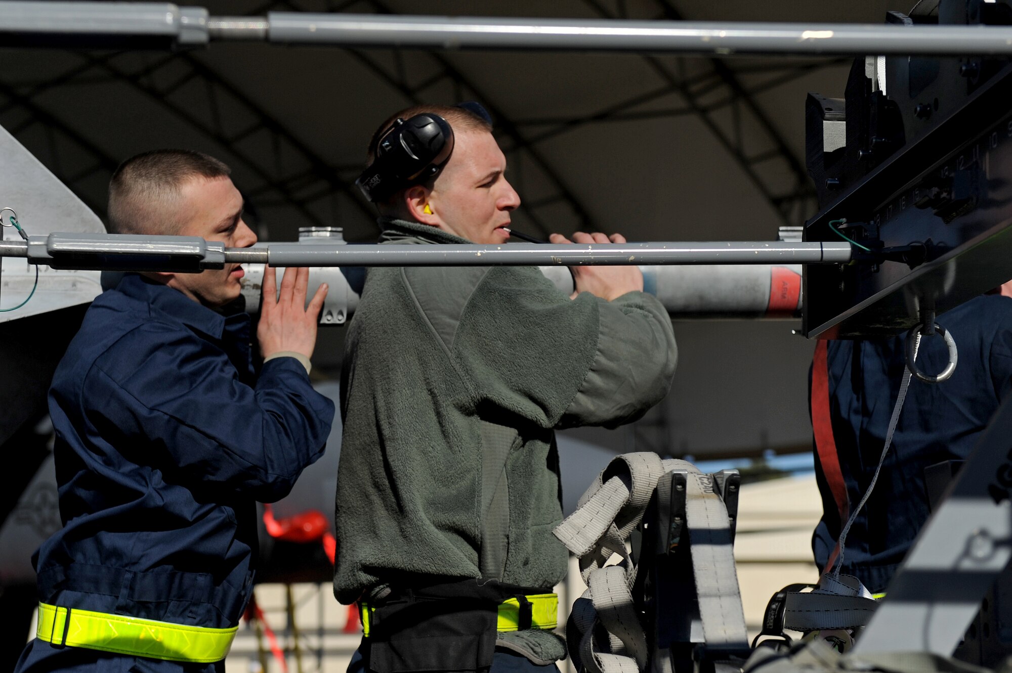 Senior Airman Donald Templeton, left, and Staff Sgt. Kevin McKnight, 4th Aircraft Maintenance Squadron load crew members, remove an Air Intercept Missile (AIM-9 Sidewinder) from a munition trailer during a load crew competition of the quarter at Seymour Johnson Air Force Base, N.C., Jan. 24, 2013. The AIM-9 is a short-range air-to-air missile. (U.S. Air Force photo by Airman 1st Class Aaron J. Jenne)