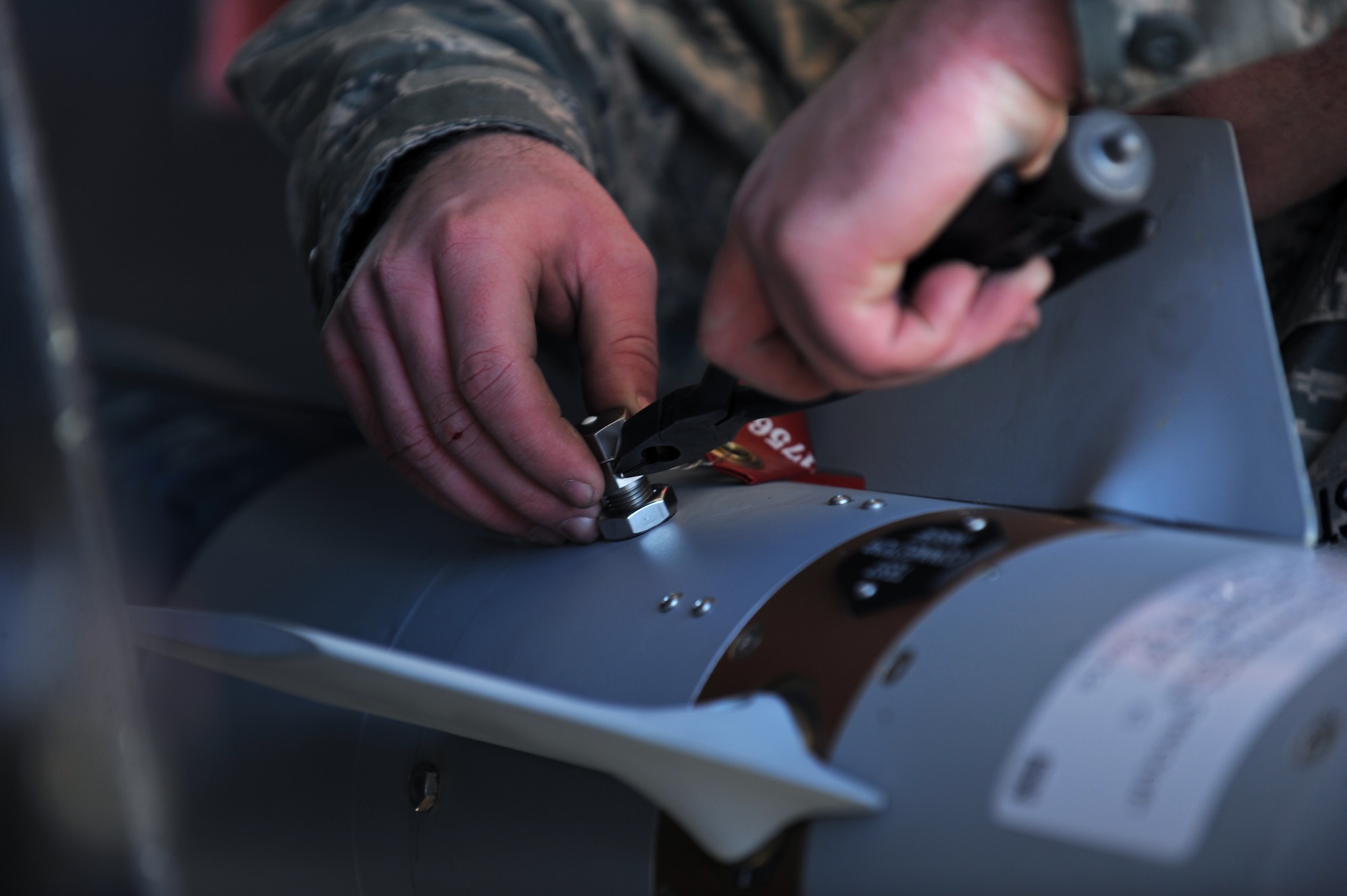 A load crew member assigned to the 4th Aircraft Maintenance Squadron completes the finishing touches after loading a Guided Bomb Unit (GBU-12) laser guided bomb during a load crew of the quarter competition at Seymour Johnson Air Force Base, N.C., Jan. 24, 2013. The BFD initiates the process that allows the bomb to hit its designated target. (U.S. Air Force photo by Airman 1st Class Aaron J. Jenne)
