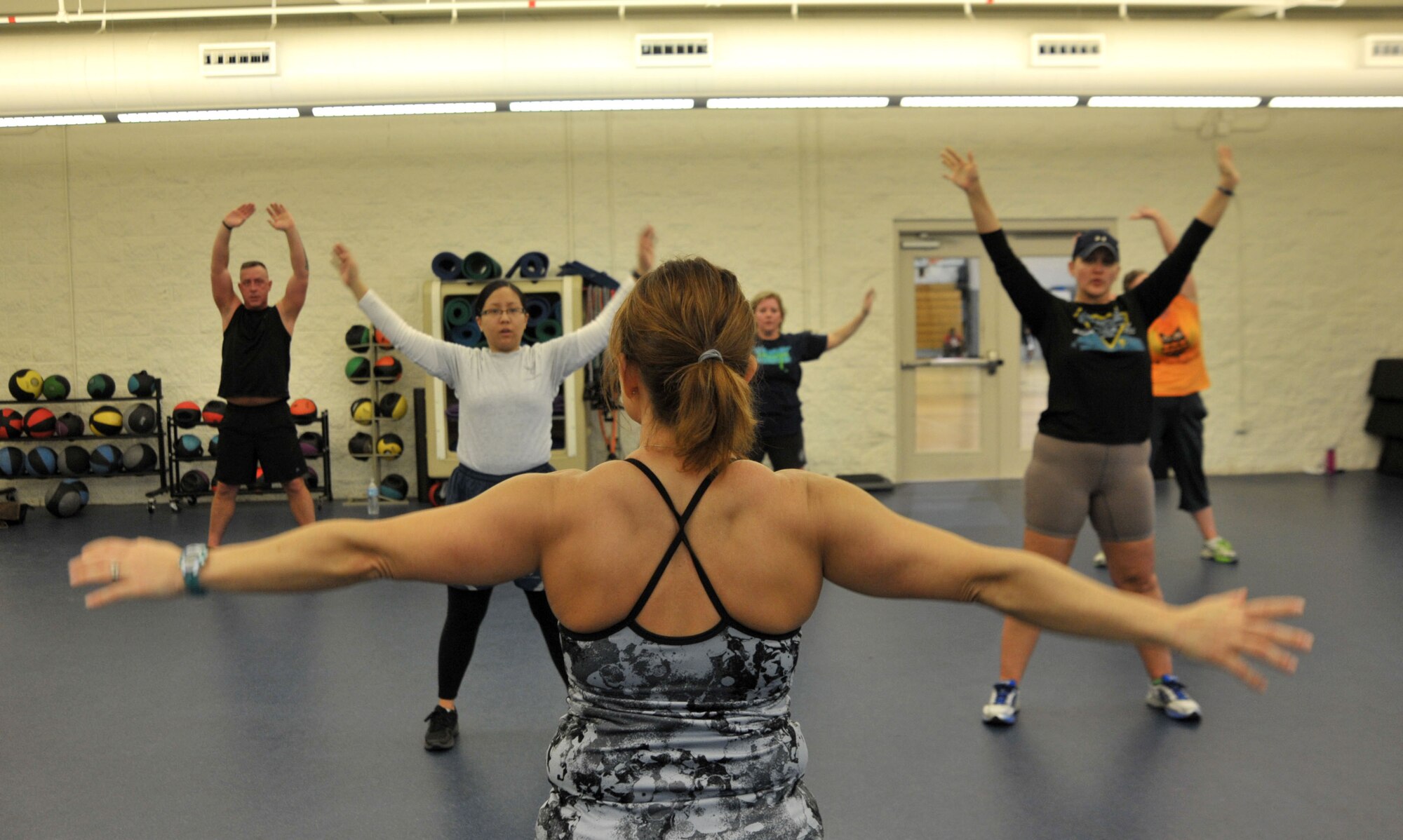 Nicole Larson, Aderholt Gym Kettlebell Fit instructor, leads the class in stretches at Hurlburt Field, Fla., Jan. 27, 2014. Larson said a 45-minute workout with kettlebells  can target flexibility, cardio, strength and endurance. (U.S. Air Force photo/Airman 1st Class Andrea Posey)
