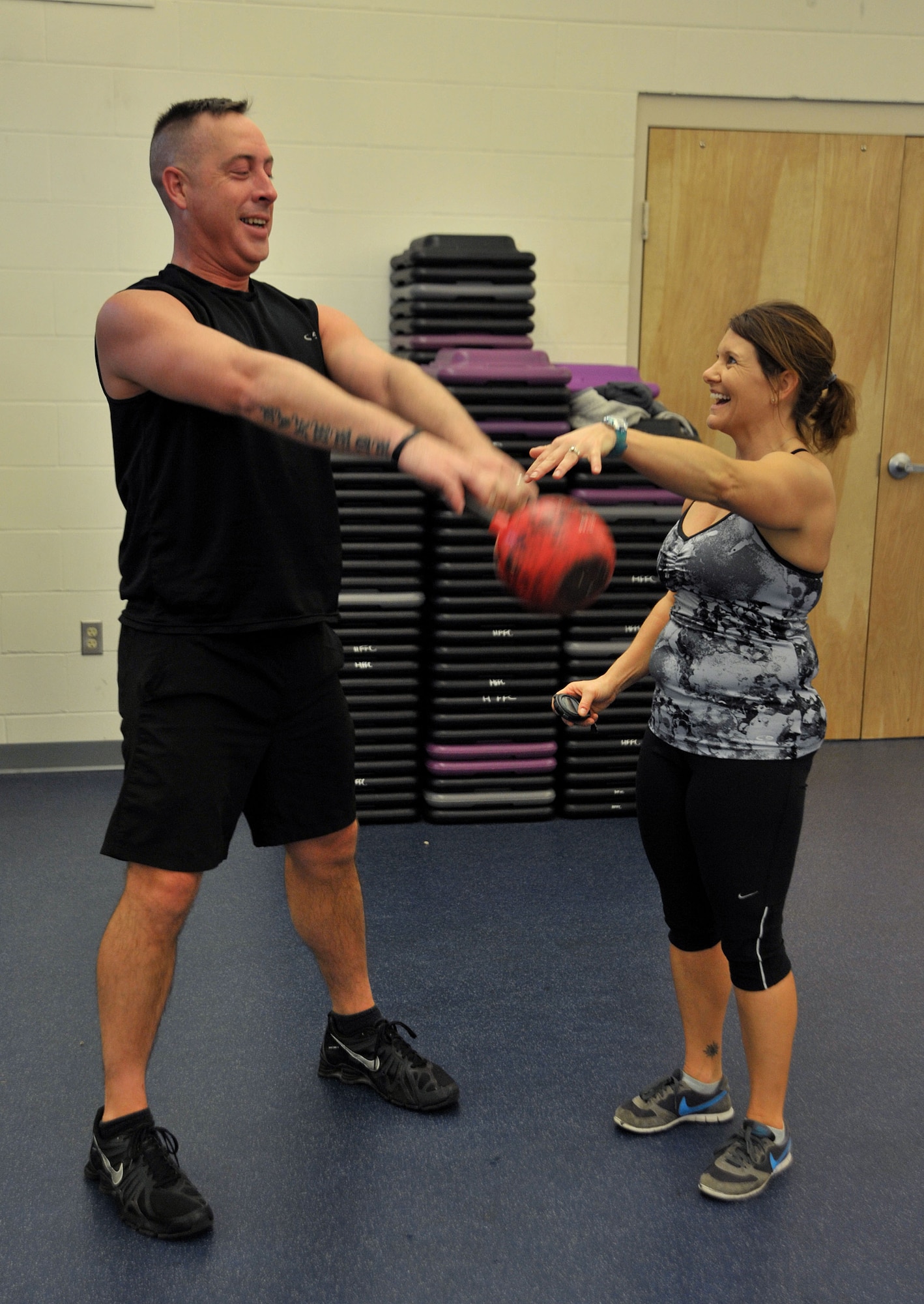 Nicole Larson, Aderholt Gym Kettlebell Fit instructor, helps a student with his form at Hurlburt Field, Fla., Jan. 27, 2014. Proper lifting techniques with kettlebells involve lifting with the abdominal wall and back muscles, not arms, Larson said. (U.S. Air Force photo/Airman 1st Class Andrea Posey)