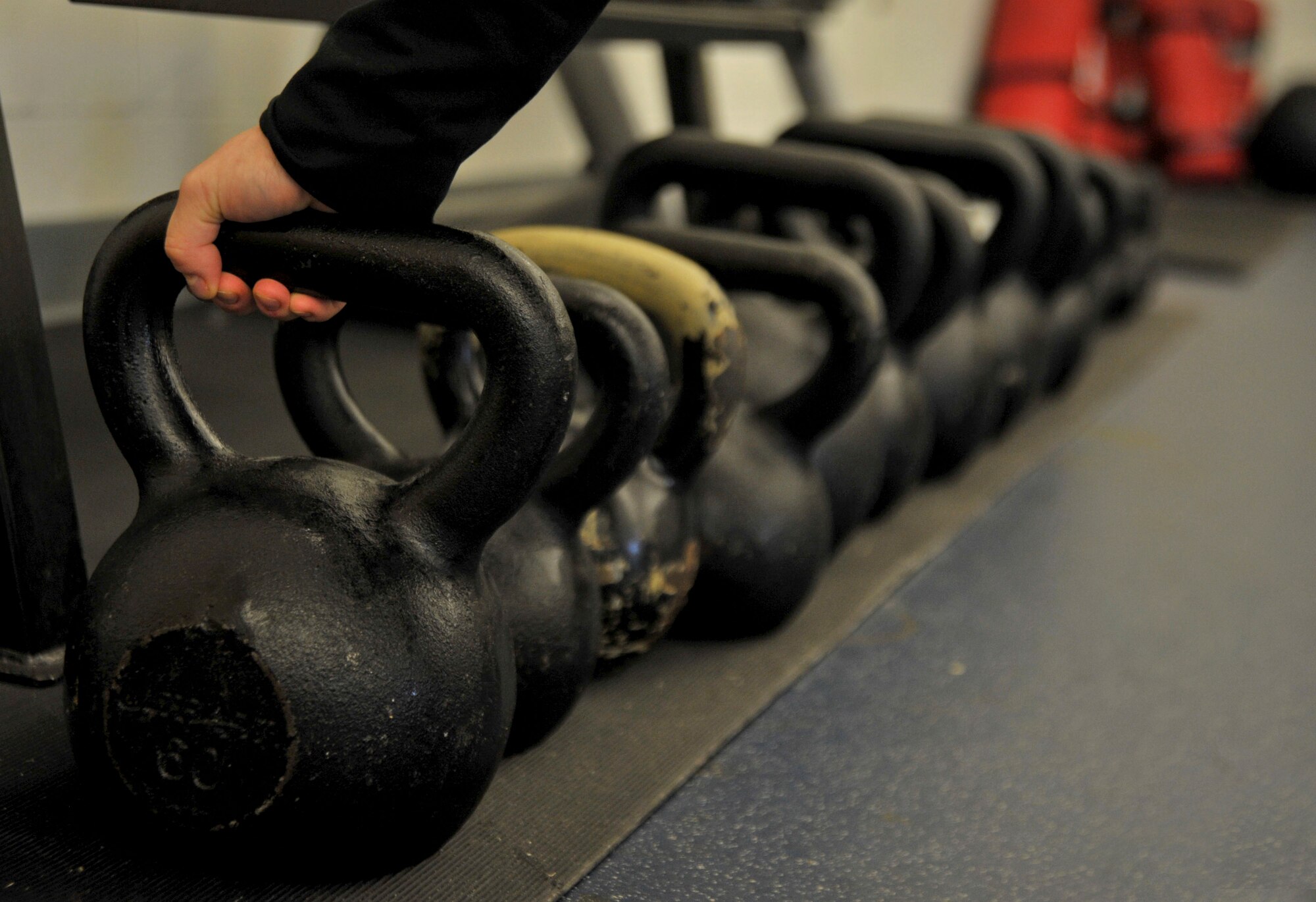Nicole Larson, Aderholt Gym Kettlebell Fit class instructor, reaches for a kettlebell at Hurlburt Field, Fla., Jan. 27, 2014. Kettlebell training is a weight-in-motion workout, which focuses on cardiovascular, flexibility, strength and balance. (U.S. Air Force photo/Airman 1st Class Andrea Posey)