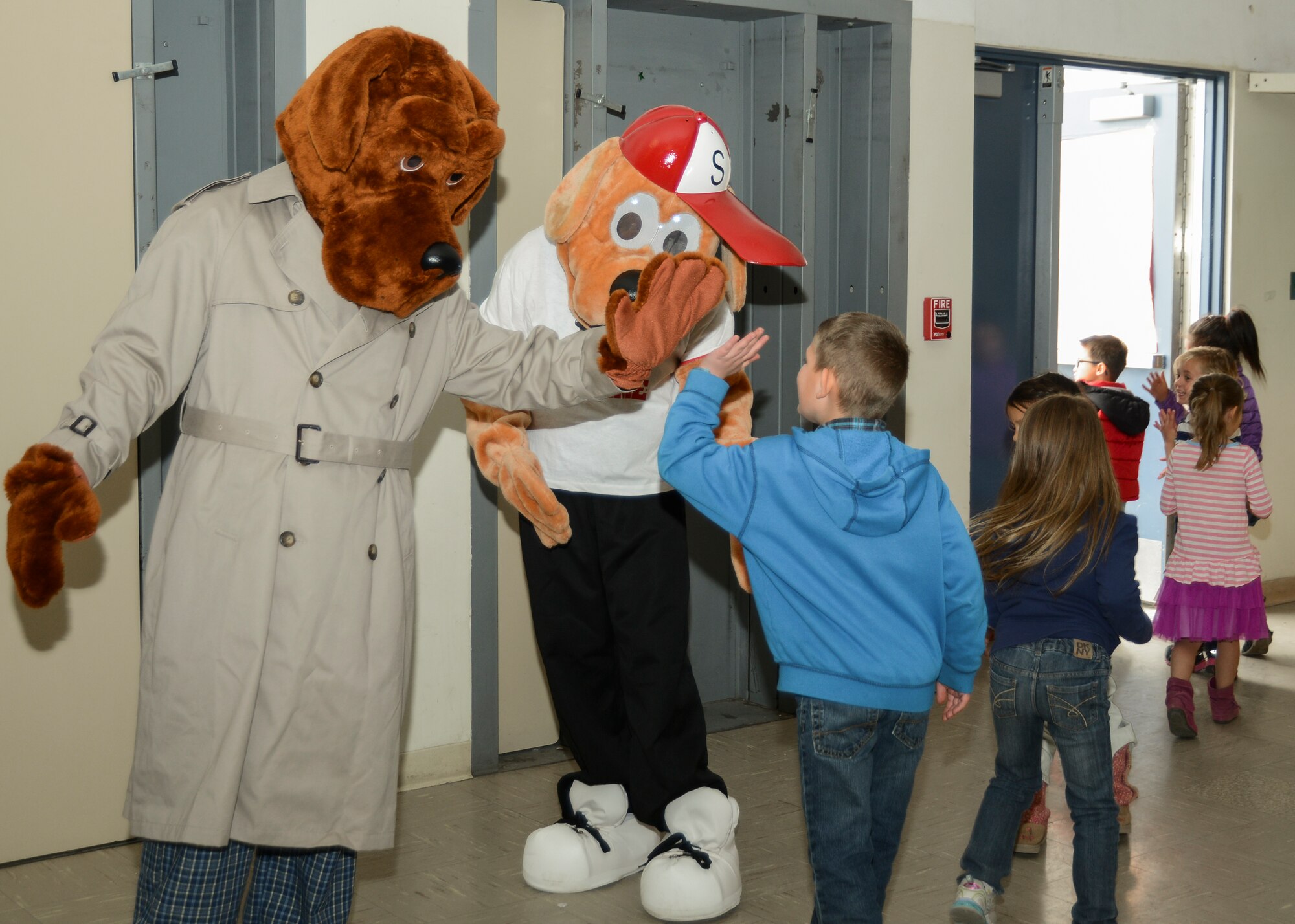 McGruff (left) and his nephew Scruff (right), portrayed by Senior Airman Anthony Betancourt, 412th Security Forces Squadron, Reports and Analysis, high-fives students following the anti-bullying presentation. (U.S. Air Force photo by Rebecca Amber)