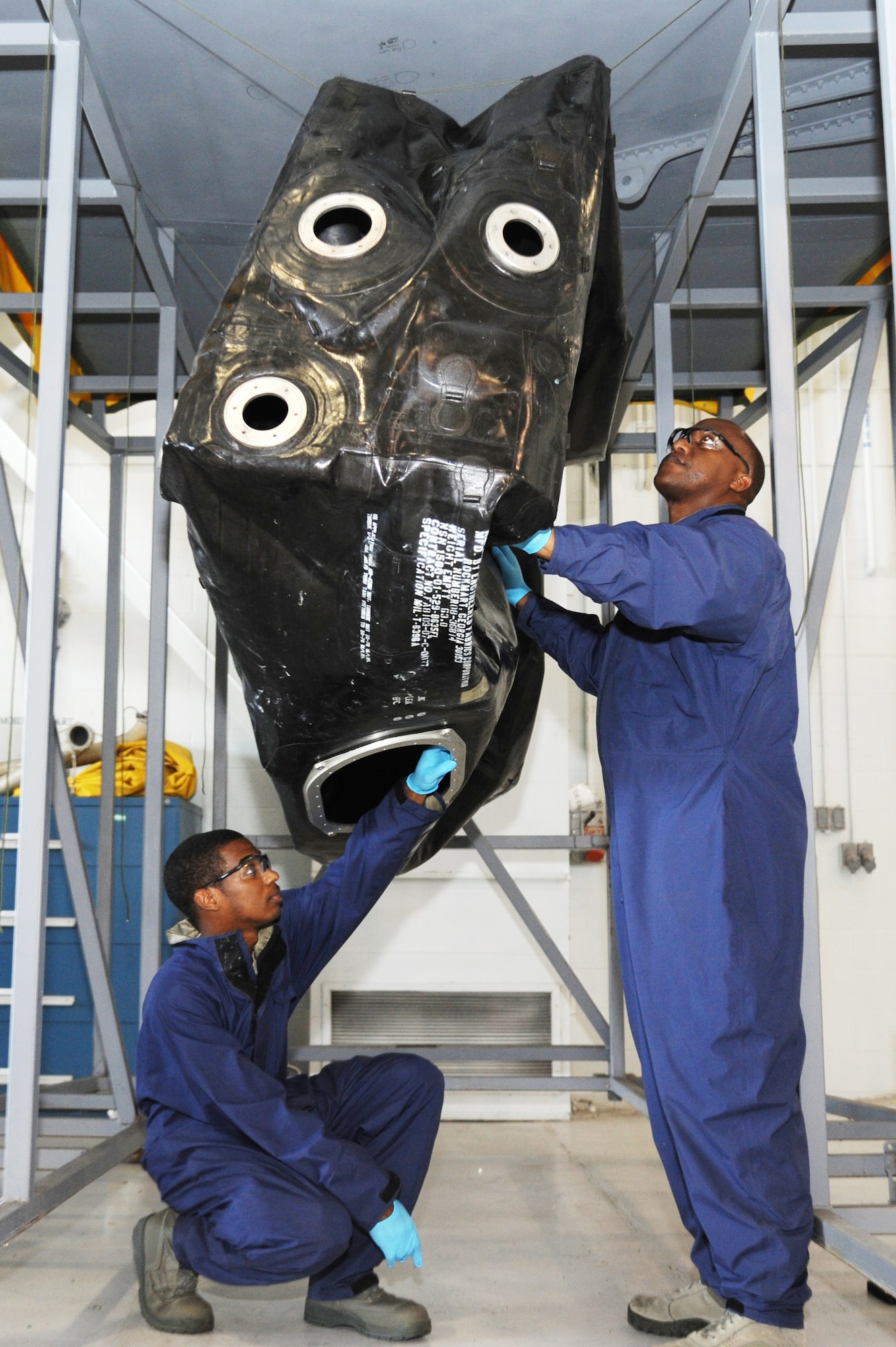 Senior Airman Clarence Brooks, 6th Maintenance Squadron, and Staff Sgt. Vince Williams, 927th Maintenance Squadron, inspect a fuel bladder from a KC-135 Stratotanker underneath a fuel cell trainer January 28, 2014, at MacDill Air Force Base, Fla.  The 6th and 927th MXS use fuel cell trainers, made from parts of a decommissioned KC-135, to help maintainers practice various repairs for the aerial refueling aircraft.  (U.S. Air Force photo by Staff Sgt. Jennie Chamberlin)