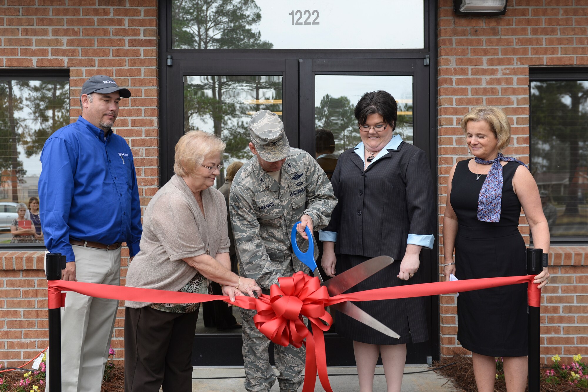 U.S. Air Force Col. Chad Franks, 23d Wing commander, and family housing directors cut the ribbon during the grand opening of the family housing community center at Moody Air Force Base, Ga., Feb. 4, 2014. Franks mentioned the opening of the community center relates to the wing’s priorities: mission, family, fun. (U.S. Air Force photo by Senior Airman Olivia Bumpers/Released)