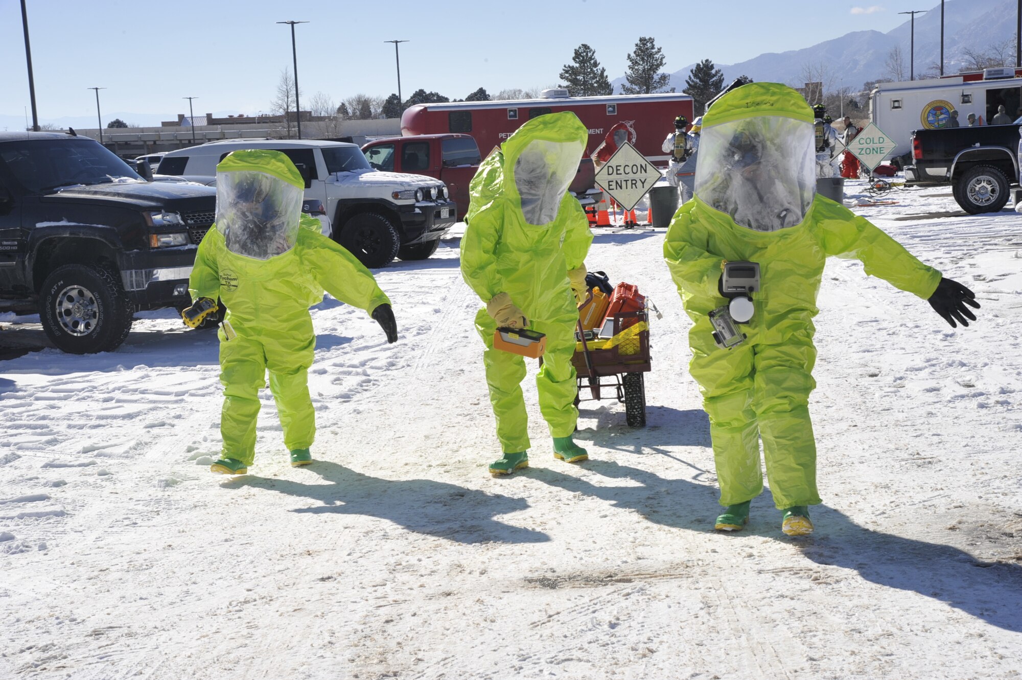 PETERSON AIR FORCE BASE, Colo. – Airmen from the 21st Medical Squadron don protective gear before approaching a suspected chemical agent located inside a dumpster during an emergency management exercise here Jan. 28. Condor Crest is designed to test and evaluate installation response to a real-world crisis or base wide situation that requires command and control, first responder employment and cooperation with local law enforcement and community leaders. (U.S. Air Force photo/Robb Lingley)