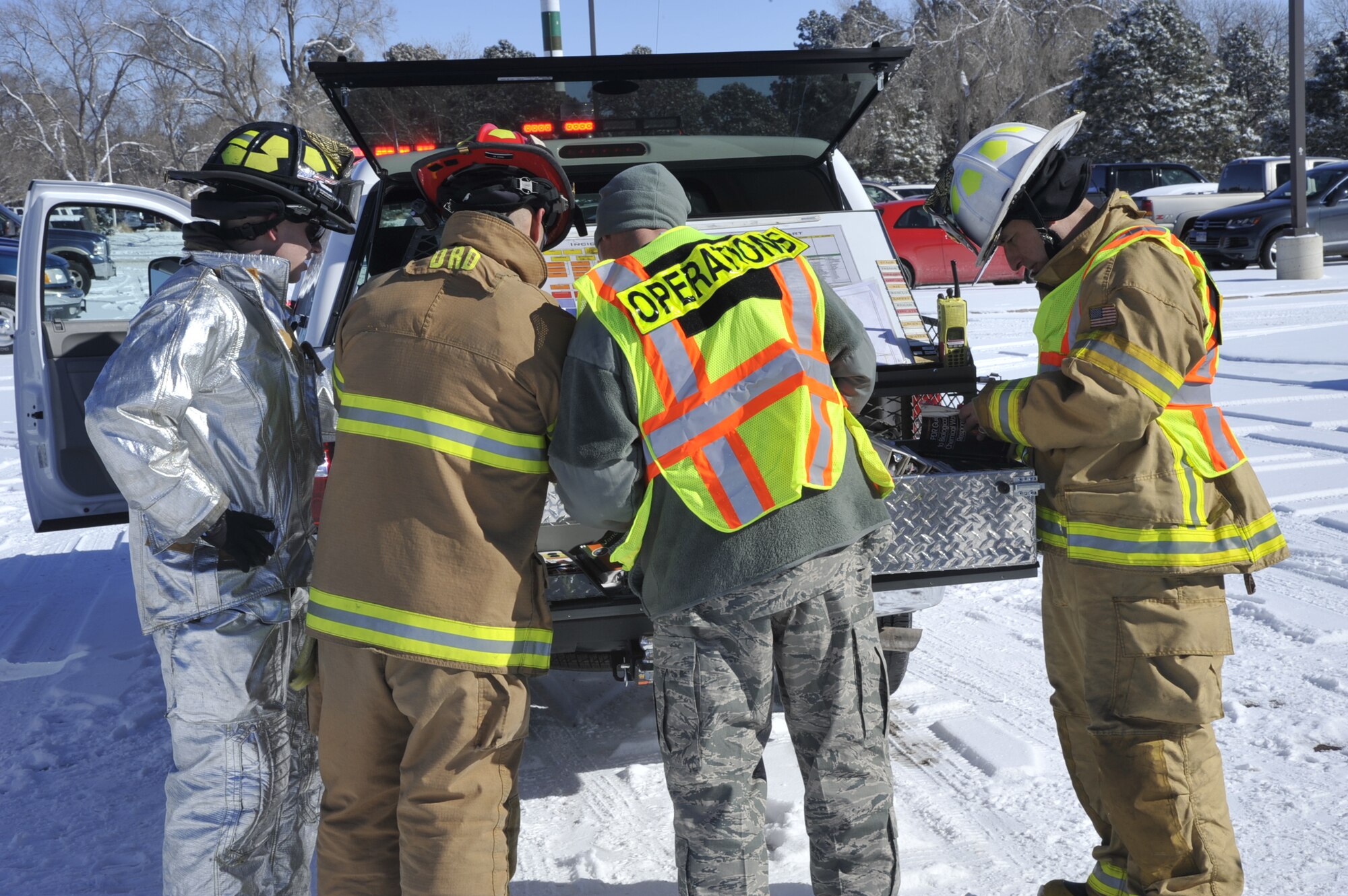 PETERSON AIR FORCE BASE, Colo. – Airmen and civilian first responders with the incident command discuss a course of action during an emergency management exercise here Jan. 28. Condor Crest is designed to test and evaluate installation response to a real-world crisis or base wide situation that requires command and control, first responder employment and cooperation with local law enforcement and community leaders. (U.S. Air Force photo/Robb Lingley)