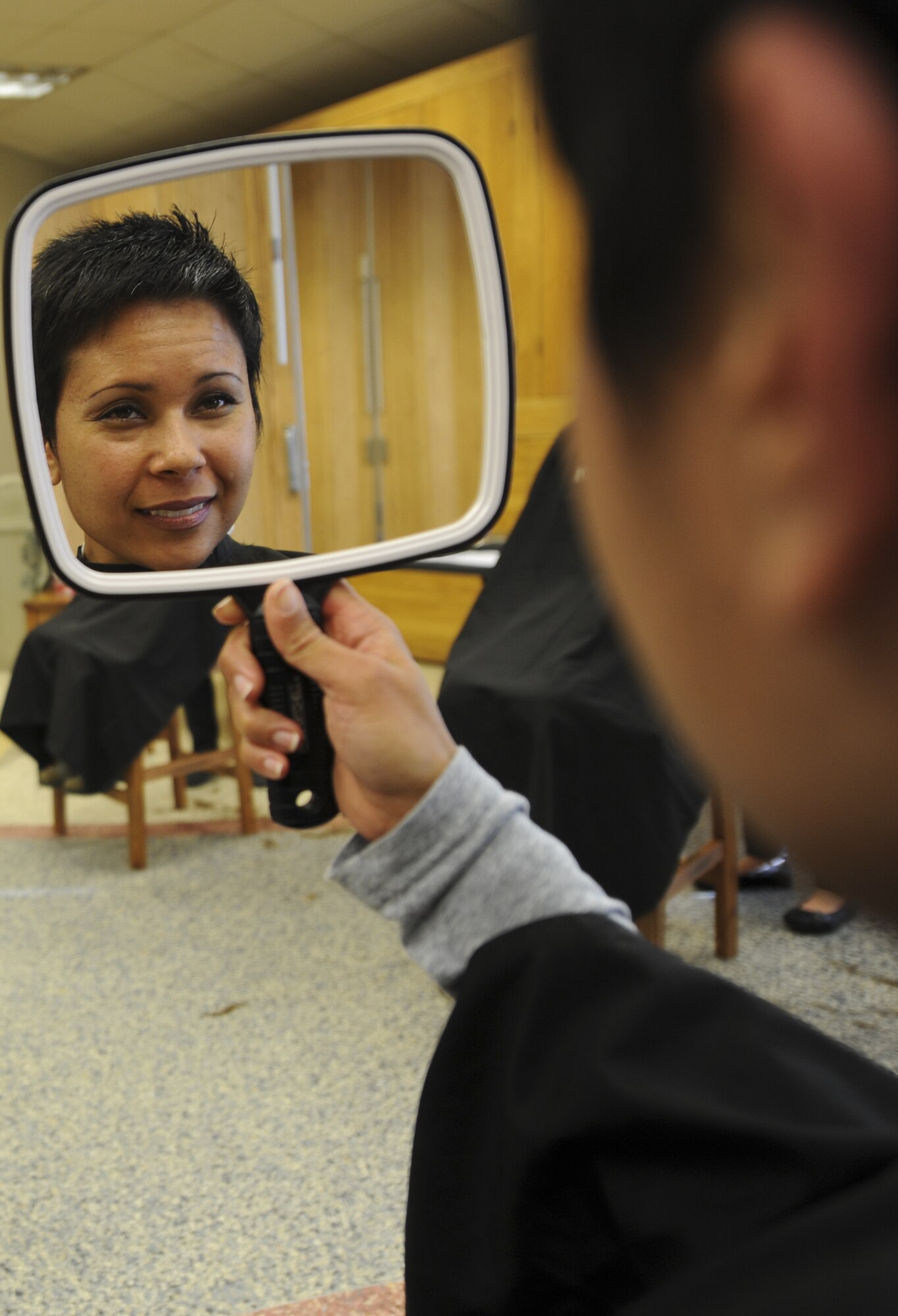 Tech. Sgt. Jenet Shaffner, 561st Network Operations Squadron, looks at her new short haircut after donating four, 10-inch locks of hair Jan. 24, at the Peterson Chapel. The Locks For Love, “Give a Little, Give a Lock” event gathered more than 19, 10-inch long locks of hair for children with long term hair loss illnesses. (U.S. Air Force photo/Staff Sgt. Jacob Morgan)