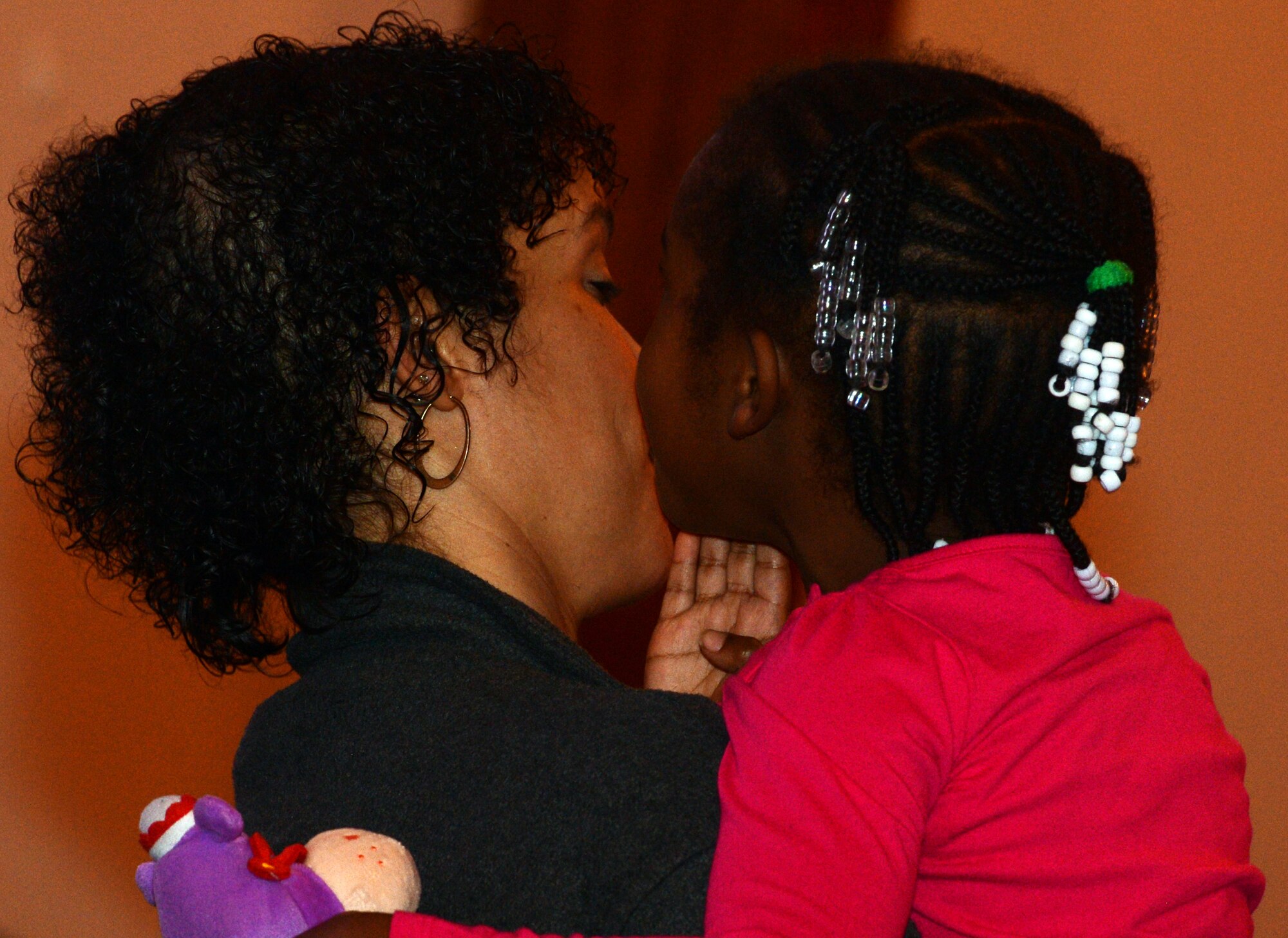 A mother and daughter share an embrace and kiss during the Celebration of Gospel event held by the 20th Fighter Wing Chapel at the Palmetto Chapel, Shaw Air Force Base, S.C., Feb. 1, 2014. The congregation came together to remember and celebrate their shared history and the influence of gospel on the world today. (U.S. Air Force photo by Airman 1st Class Jonathan Bass/Released)