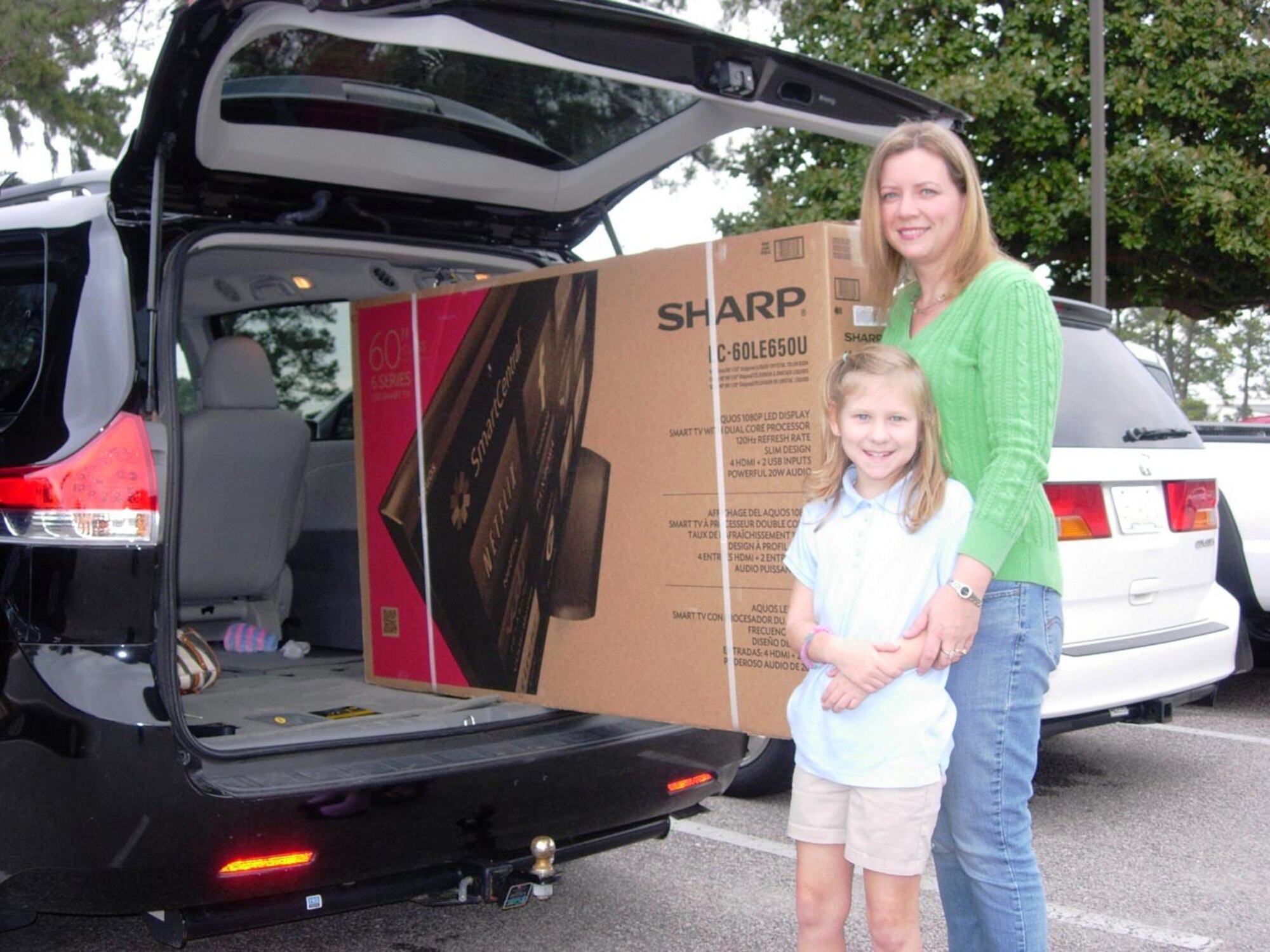 Heidi Wingo, wife of Lt. Col. Joseph Wingo, 628th Communications Squadron commander, was the grand prize winner of the drawing for a 60” flat screen television Feb. 2, 2014, during the Charleston Club’s Super Bowl party at Joint Base Charleston – Air Base, S.C. Helping mom claim her prize and load it into the family van was 9-year old Sophia Wingo. The grand prize drawing was exclusively for Charleston Club members attending the party. “We’ve been members most of the time since he was a lieutenant,” said Wingo, referring to her husband. Where is the huge TV going when it gets home? “Not in any of the kid’s rooms!” said Wingo. (U.S. Air Force photo/Gary Grove)