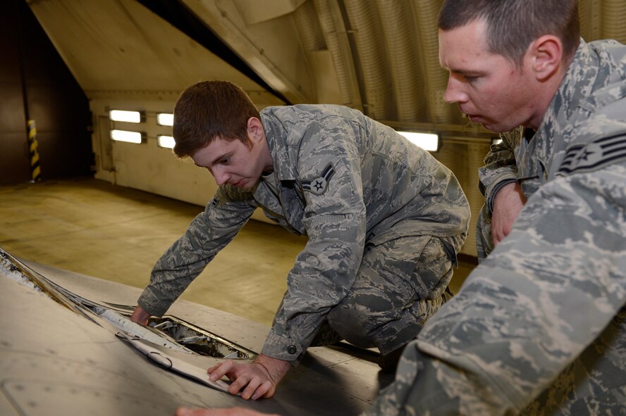 U.S. Air Force Airman 1st Class Brandon Clayton, 52nd Aircraft Maintenance Squadron aircraft armament technician from McKenzie, Tenn., and Staff Sgt. Lawson Chauncey, 52nd AMXS weapons team chief from Cocoa Beach, Fla., follow the maintenance checklist to inspect an F-16 Fighting Falcon weapons system on Spangdahlem Air Base, Jan. 28, 2014. Checklists detail every aspect of what to check and repair before the aircraft is deemed safe to fly. (U.S. Air Force photo by Staff Sgt. Christopher Ruano)