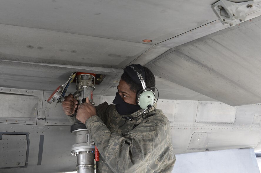U.S. Air Force Senior Airman Richard Turner, 52nd Aircraft Maintenance Squadron engine technician from Nork, N.J., fastens a type-4 hydrant system to refuel an F-16 Fighting Falcon during a hot-pit refueling at Spangdahlem Air Base, Jan 28, 2014. Hot-pit refueling saves time, manpower and equipment usage by refueling active aircraft between training missions. (U.S. Air Force photo by Staff Sgt. Christopher Ruano/released)