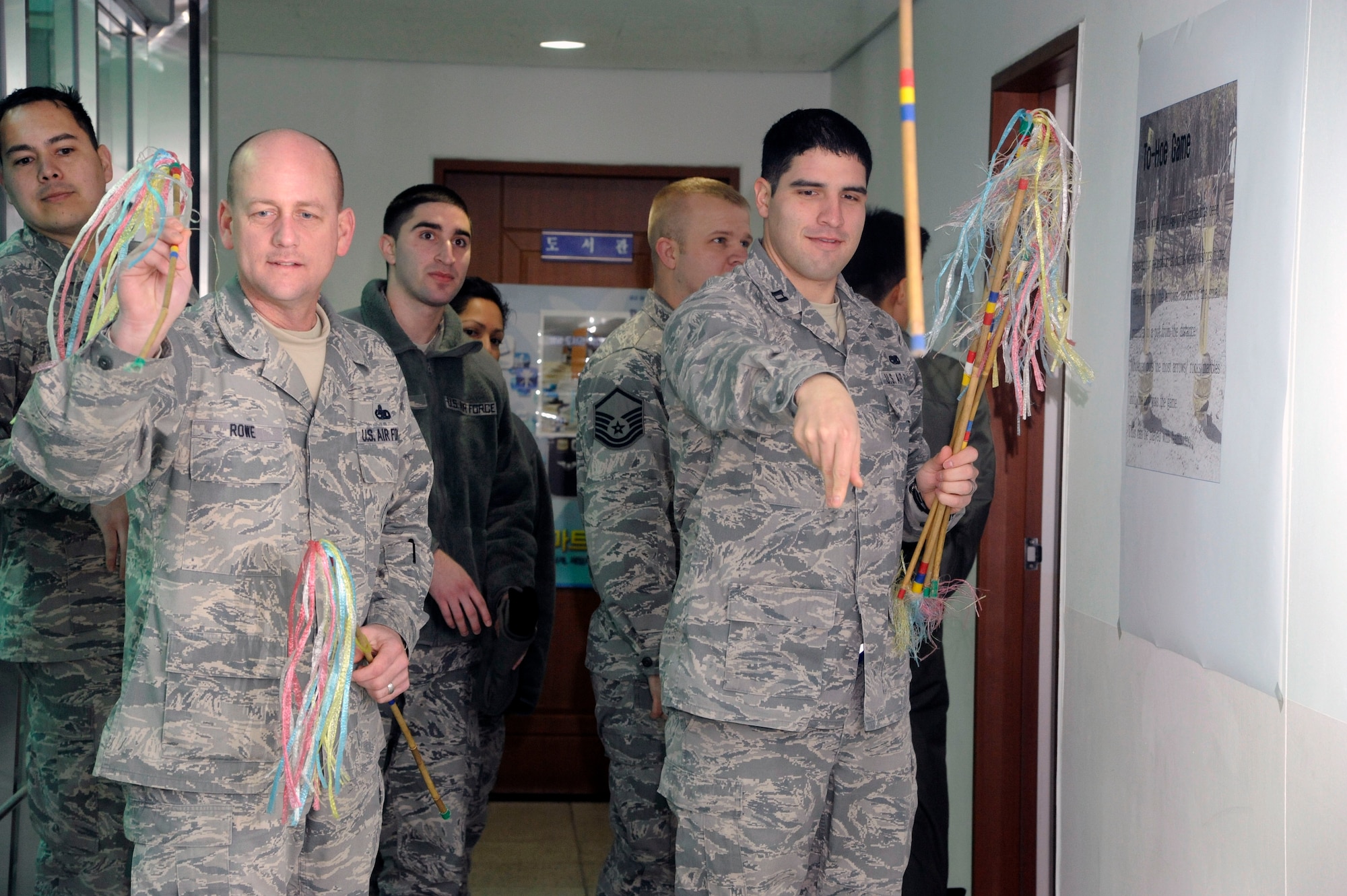 Senior Master Sgt. Christopher Rowe, 8th Aircraft Maintenance Squadron weapons section flight chief, and Capt. Anthony Tuero, 8th AMXS 35th Aircraft Maintenance officer in charge, participate in a traditional game called To-Hoe as part of the Lunar New Year celebration at Kunsan Air Base, Republic of Korea, Feb. 1, 2014. To-Hoe has been played in the past for the reception of when visitors come to visit. The objective is to throw as many arrows as possible into the pot. U.S. and RoKaf Airmen came together to celebrate the new year by participating in a traditional bowing ceremony, eating Korean cuisine and playing a variety of games. (U.S. Air Force photo by Staff Sgt. Jessica Haas/Released)