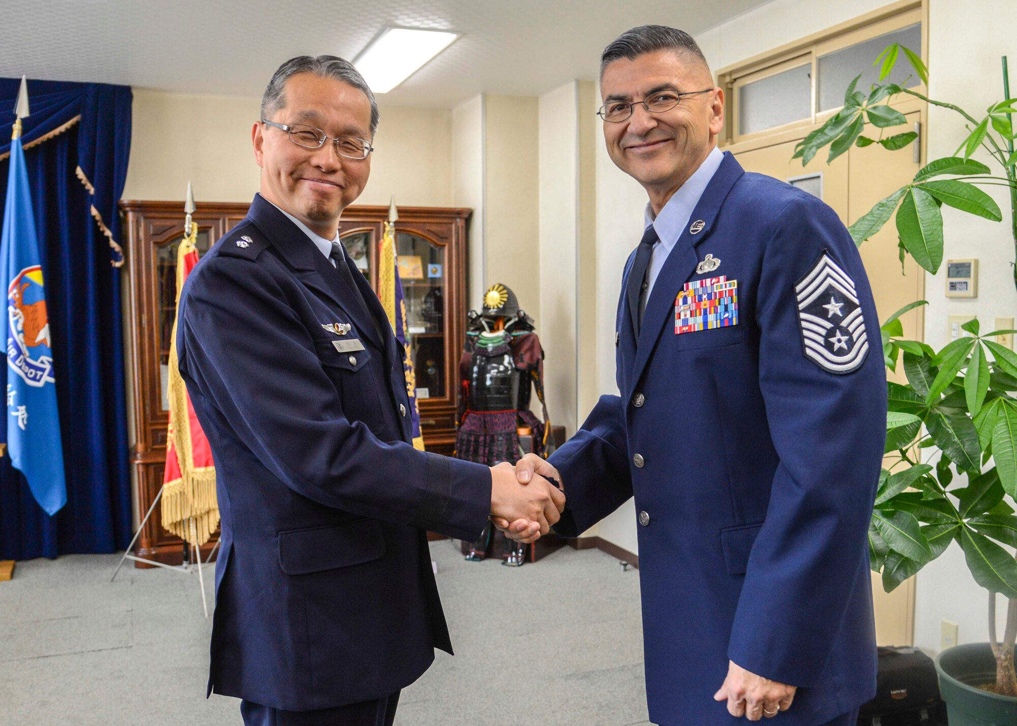 Chief Master Sgt. Manuel Roblesreynoso, 374th Airlift Wing command chief, receives a coin from Japan Air Self-Defense Forces Maj. Gen. Koichi Nishitani, 4th Air Depot commander, Jan. 30, 2014, at Iruma Air Base, Japan.  During his visit to Iruma AB, Chief Roblesreynoso observed the Tech. Sgt. training courses and toured the on-base JASDF history museum.  (U.S. Air Force photo by Airman 1st Class Soo C. Kim / released)