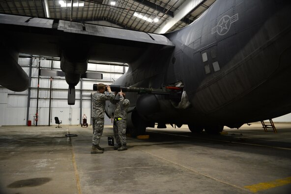 Staff Sgt. Seth Rosbrugh, 27th Special Operations Maintenance Squadron armament technician Airman 1st Class Thomas Orton-McIntyre, 27 SOMXS armament technician, remove a 105 mm blast diffuser from the AC-130H Spectre. The men and women of the 16th Aircraft Maintenance Unit have had the sole responsibility of inspecting, repairing and maintaining these gunships throughout their tenure at Cannon Air Force Base, N.M., and even since they served in Vietnam. (U.S. Air Force photo/ Airman 1st Class Eboni Reece)
 