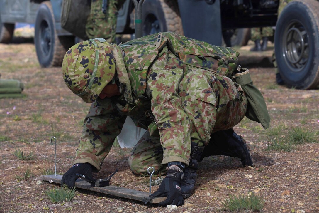 A soldier from the Japan Ground Self-Defense Force plots grid coordinates for placing a 120mm mortar system during Exercise Iron Fist 2014 aboard Camp Pendleton, Calif., Feb. 3, 2014.  Iron Fist 2014 is an amphibious exercise that brings together Marines and sailors from the 15th Marine Expeditionary Unit, other I Marine Expeditionary Force units, and soldiers from the JGSDF, to promote military interoperability and hone individual and small-unit skills through challenging, complex and realistic training. (U.S. Marine Corps photo by Sgt. Jamean R. Berry/Released)