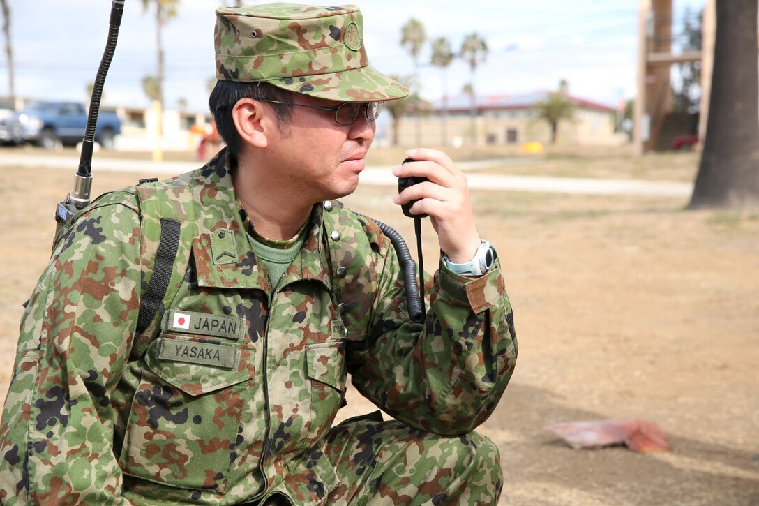 A soldier with the Japan Ground Self-Defense Force and U.S. Marines with the 15th Marine Expeditionary Unit conduct radio checks during Exercise Iron Fist 2014 aboard Camp Pendleton, Calif., Feb. 4, 2014. Iron Fist 2014 is an amphibious exercise that brings together Marines and sailors from the 15th MEU, other I Marine Expeditionary Force units, and soldiers from the JGSDF, to promote military interoperability and hone individual and small-unit skills through challenging, complex and realistic training. (U.S. Marine Corps photo by Lance Cpl. Anna K. Albrecht/Released)