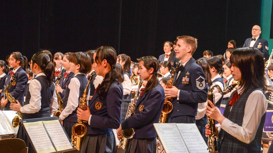 Master Sgt. Dwight Wiest, the United States Air Force Band of the Pacific-Asia saxophonist, and Japanese student performer’s stand after an ensemble during Japan - U.S. Joint Concert at Tachikawa City, Japan, Feb. 2, 2014.  Members of PACAF Band performed side-by-side with Japanese students to play live music during the annual event.  (U.S. Air Forces photo by Airman 1st Class Soo C. Kim / released)
