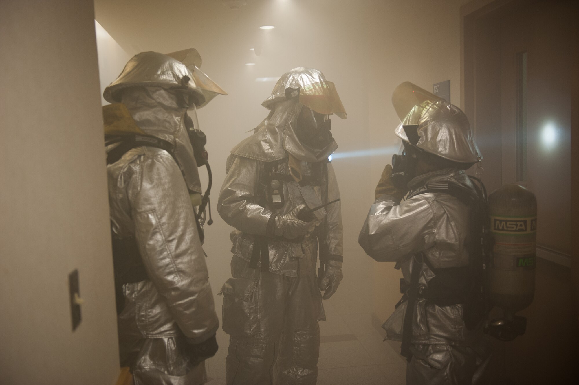 Eighth Civil Engineer Squadron firefighters discuss how to clear a damaged building during exercise Beverly Midnight 14-01 at Kunsan Air Base, Republic of Korea, Feb. 5, 2014. The fire department responded to a simulated dormitory fire started by a simulated missile attack and resulting explosion. (U.S. Air Force photo by Staff Sgt. Clayton Lenhardt/Released)