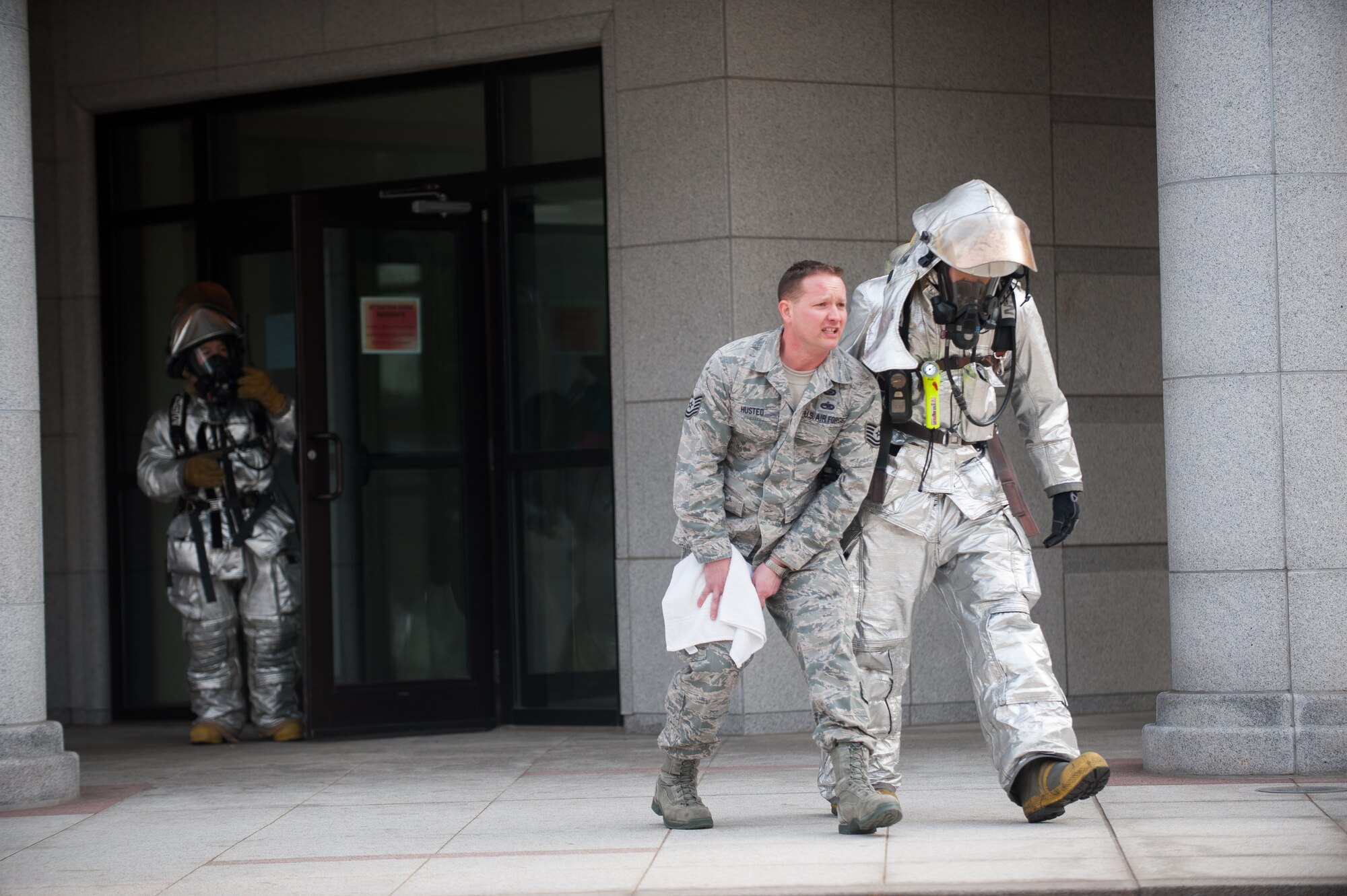 Staff Sgt. Jonathan Florendo, 8th Civil Engineer Squadron firefighter, assists Tech. Sgt. Nicholas Husted, 8th Force Support Squadron exercise role player, out of a damaged building during exercise Beverly Midnight 14-1 at Kunsan Air Base, Republic of Korea, Feb. 5, 2014. Role players are appointed from different sections across the wing and act out exercise scenarios for the base to respond to. (U.S. Air Force photo by Staff Sgt. Clayton Lenhardt/Released)