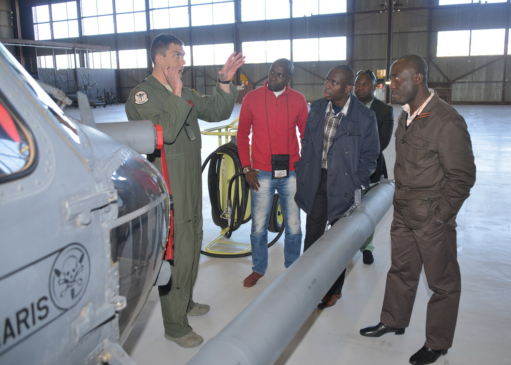 Maj. Josh Irvine, 512th Rescue Squadron, explains the features of the
HH-60G Pavehawk helicopter to a group of men visiting from Angola, Africa. The  Angolans toured the 58th Special Operations Wing Jan. 30 to learn more about search and rescue operations, . (Photo by Todd Berenger)