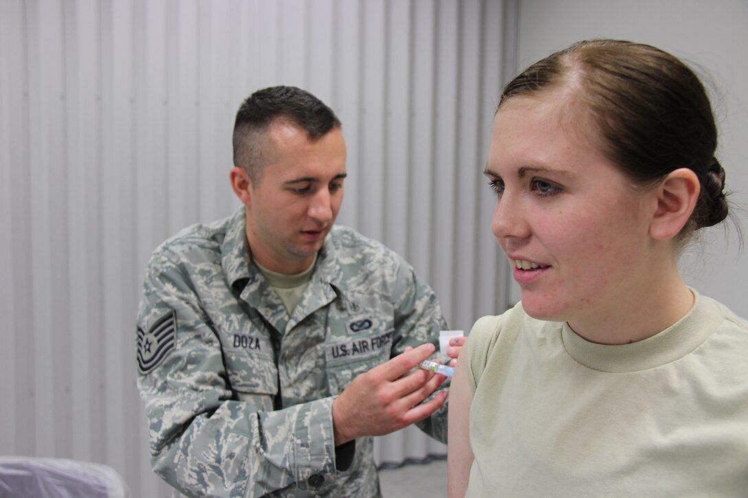 Tech. Sgt. Nathan Doza gives a flu shot to Airman 1st Class Ashley Meacher as part of the 932nd Airlift Wing's fight against the flu season in the Illinois region.  If members haven't had the shot through a civilian doctor they should be getting it during the unit training assembly held next on February 8-9 at the unit near Belleville, Ill.  (U.S. Air Force photo/Maj. Stan Paregien)