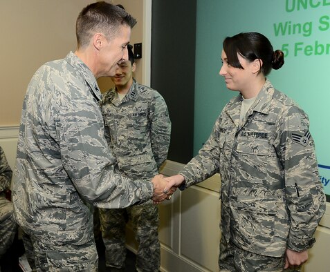Col. Scott DeThomas, 6th Air Mobility Wing commander, coins Senior Airman Taryn Summers, 91st Air Refueling Squadron, during a Wing Staff meeting at MacDill Air Force Base, Fla., Feb. 5, 2014. Summers provided emergency first responder care to a motorcycle accident victim Feb. 4, 2014. (U.S. Air Force photo/Senior Airman Shandresha Mitchell)