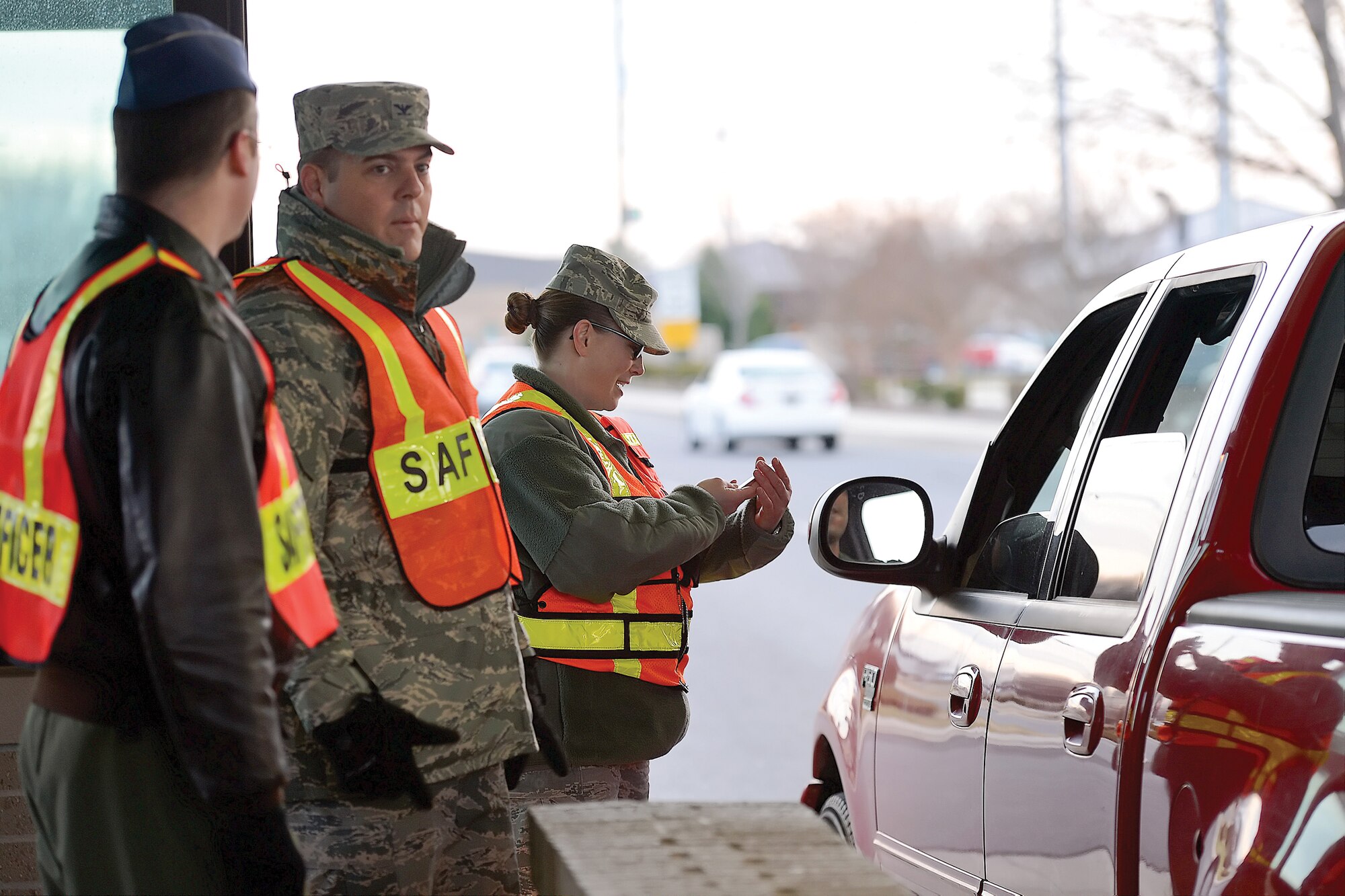 Master Sgt. Breah Misho, 436th Operations Support Squadron 1st Sgt., joins other senior leaders of the 43th Airlift Wing at the main to check identification cards and encourage safe holiday travel on Dec. 20, 2013, at Dover Air Force Base, Del. USAF photo/Greg L. Davis