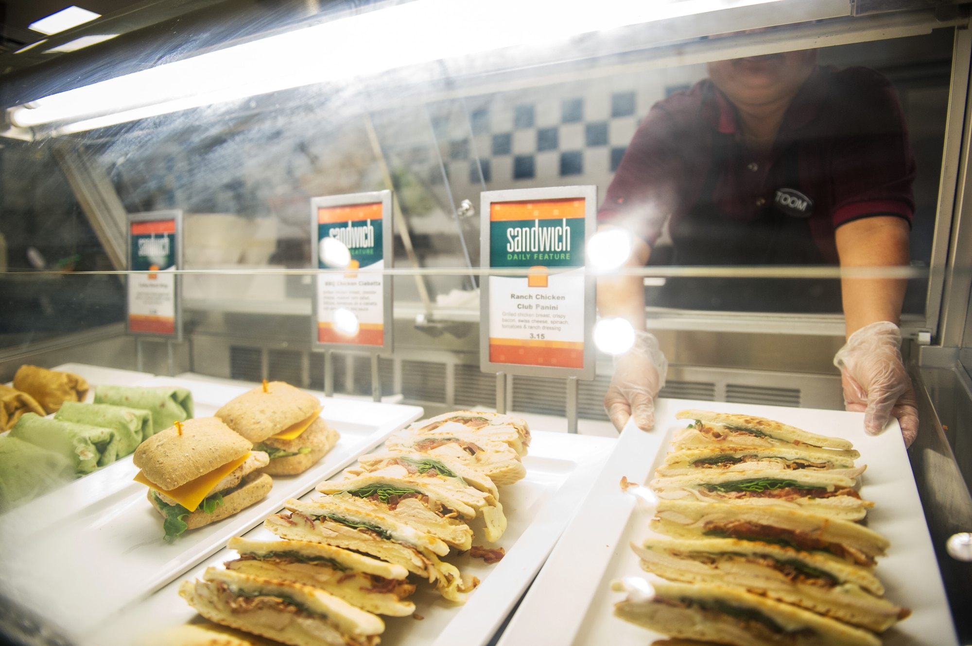 A Riverside Dining Facility employee places sandwiches in a cold case during her shift at Patrick Air Force Base Feb. 4, 2014. Several menu upgrades to the Riverside Dining Facility have been based on customer feedback. (U.S. Air Force photo/Cory Long) 