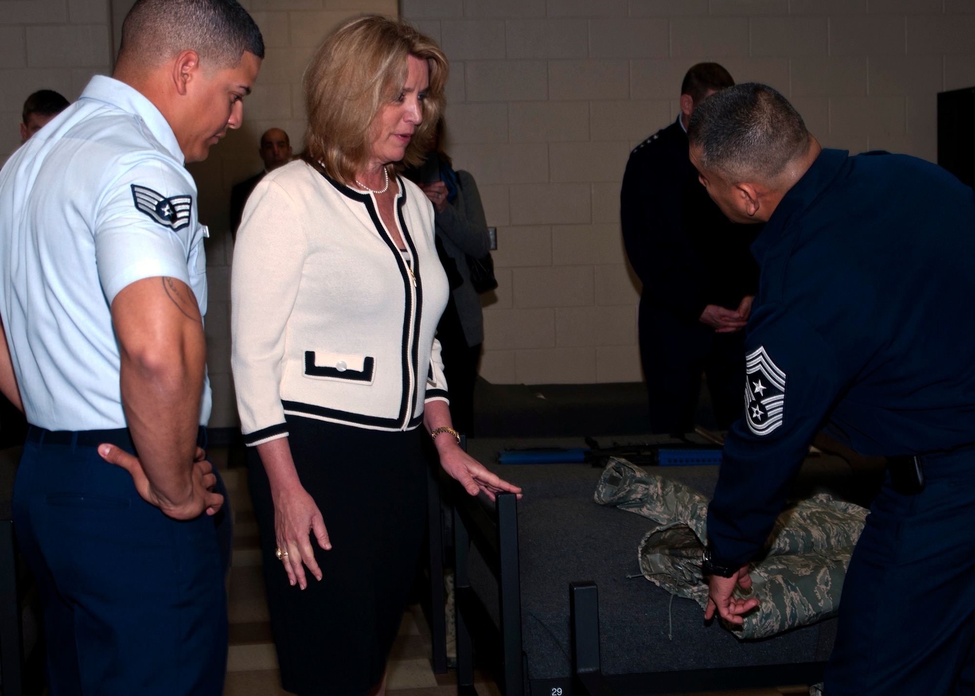 Tech. Sgt. Christian Pagan-Guzman, a basic military training instructor with the 323rd Training Squadron, left, and Chief Master Sgt. Gerardo Tapia, command chief, Air Education and Training Command, show Secretary of the Air Force Deborah Lee James the liner jacket issued to basic trainees during the SecAF’s visit to Joint Base San Antonio-Lackland Jan. 31. (U.S. Air Force photo by Staff Sgt. Marissa Tucker)