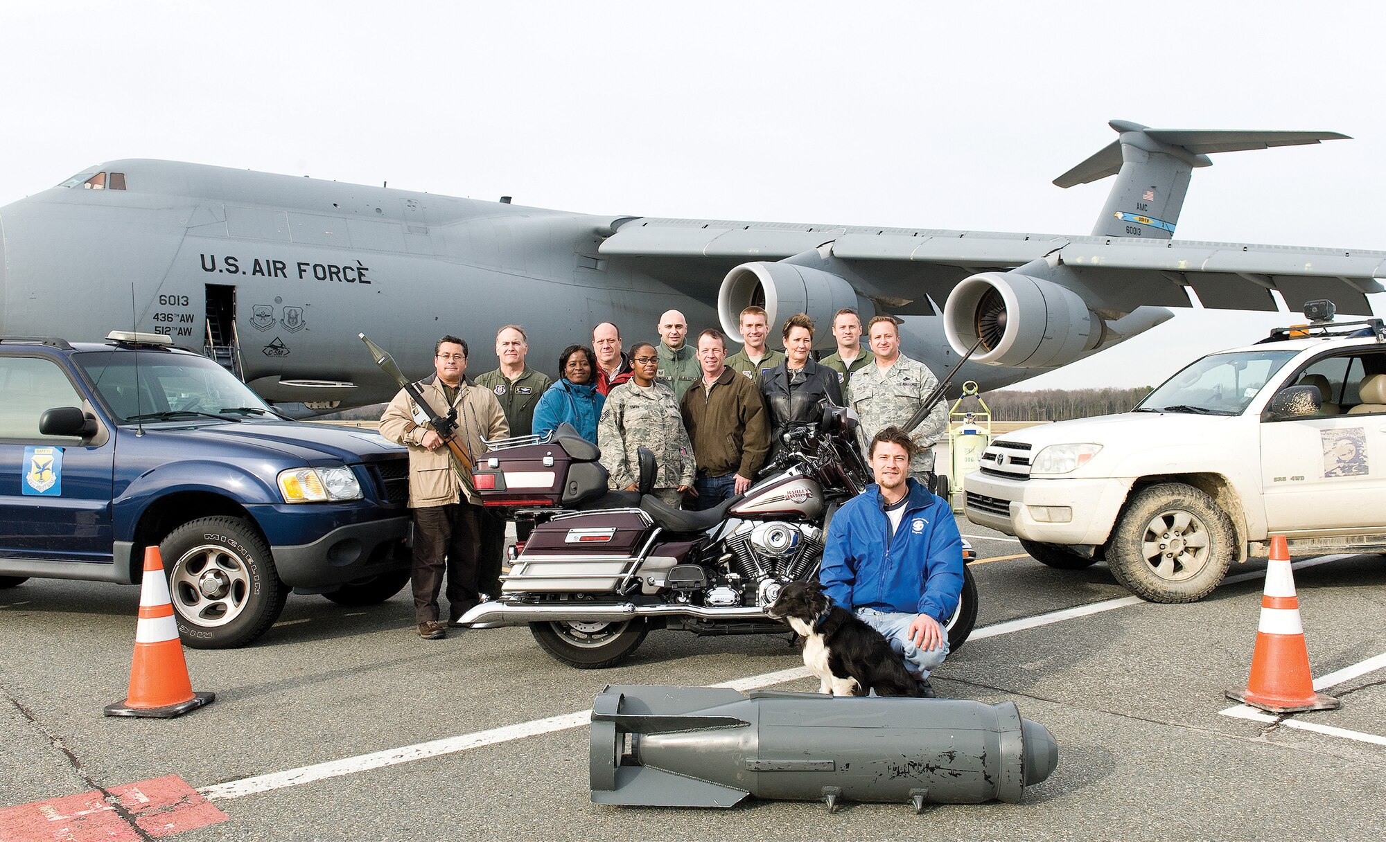 Personnel of the 436th Airlift Wing Safety Office pose for a photo on the flight line Dec. 20, 2012, at Dover Air Force Base, Del. The wing safety was named Air Mobility Command safety office of the year for 2013. A C-5M Super Galaxy, act as a backdrop for the picture. (U.S. Air Force photo/Roland Balik)