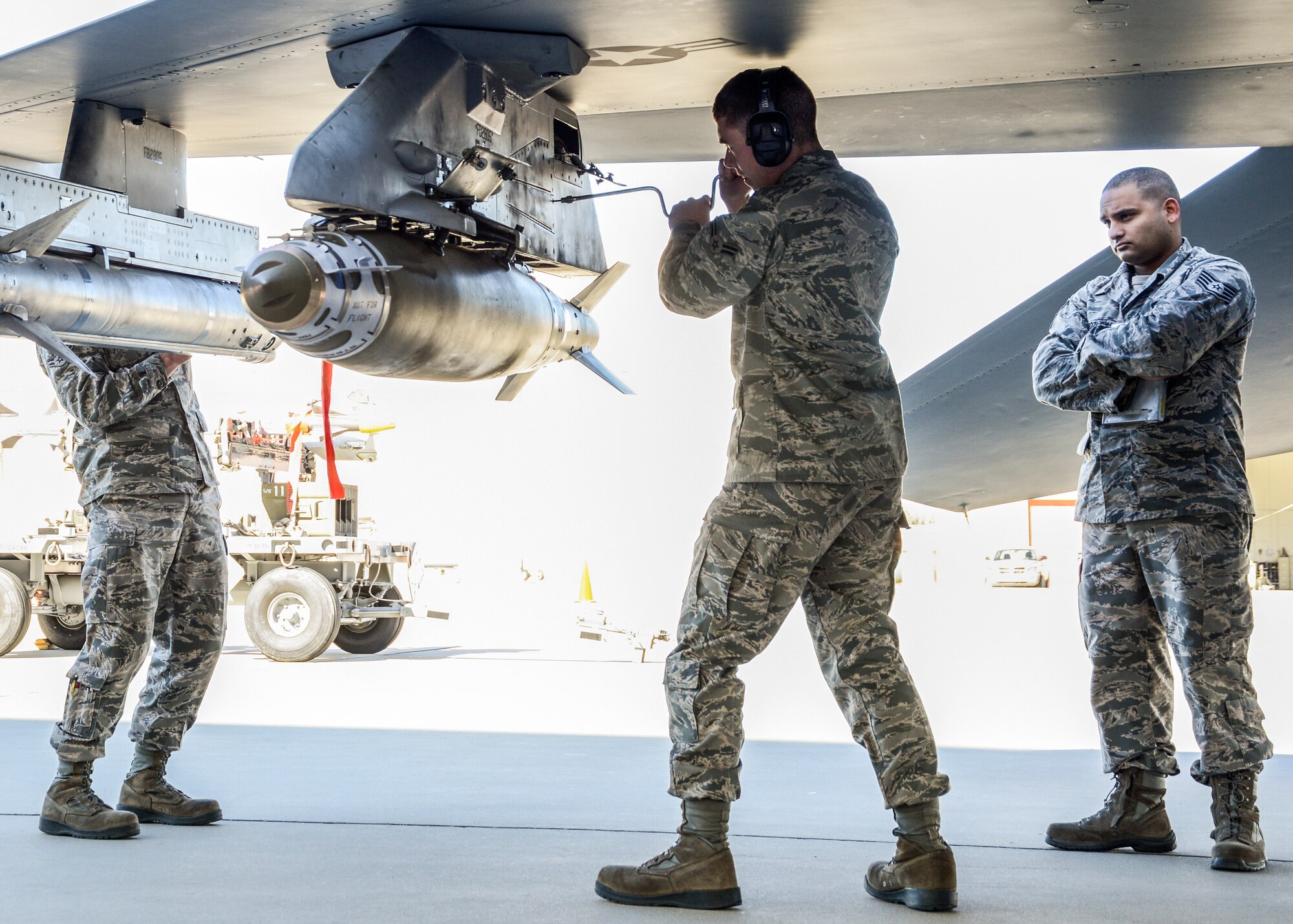 Airman 1st Class Maurice Appleton (center) is evaluated as he loads the GBU-38 JDAM onto an F-16 while Staff Sgt. Dustin Jones (left) works on the AIM-120 AMRAAM. (U.S. Air Force photo by Rebecca Amber)