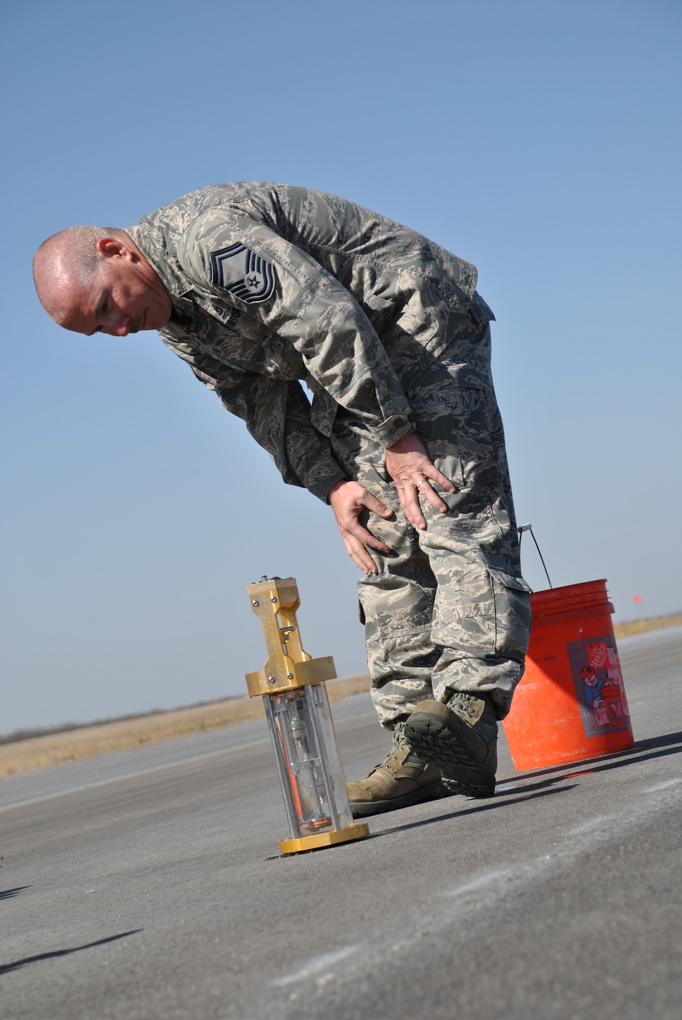 SPOFFORD, Texas -- Senior Master Sgt. Bob Dalton, the AFCEC Airfield Pavement Evaluation Team superintendent, sets a hydro-timer to gather readings to help verify adequate drainage and surface texture on the newly refinshed airfield here. (U.S. Air Force photo/Michael Briggs) 