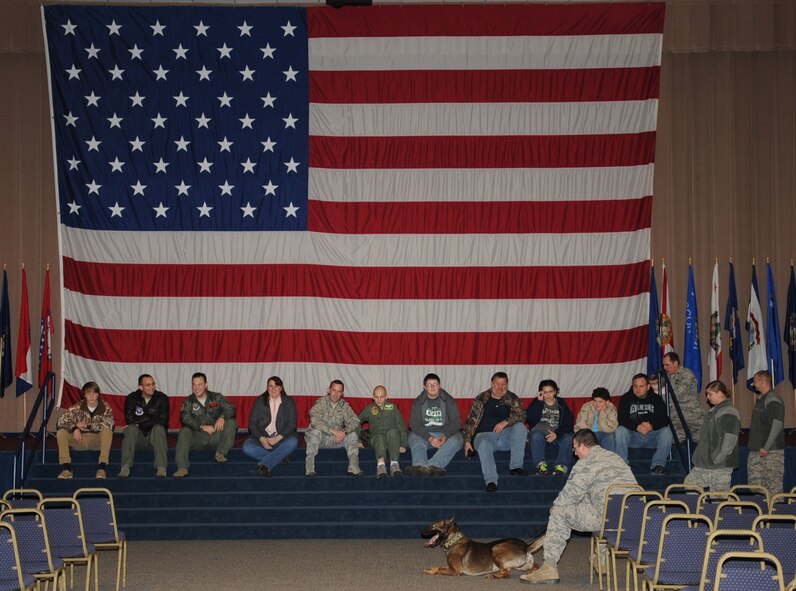 Sam Guimaraes, 17-year-old Alexandria, La. native, and friends and family, talk with Tech. Sgt. Clayton Tebbetts, 2nd Security Forces Squadron military working dog kennel master, during a MWD K-9 demonstration on Barksdale Air Force Base, La., Jan. 4, 2014. Sam and his family had the opportunity to visit various squadrons on base as part of the Pilot for a Day program. (U.S. Air Force photo/Staff Sgt. Sean Martin)