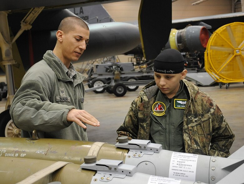 Senior Airman Gregory Quailer, 2nd Munitions Squadron conventional maintenance crew chief, explains the Guided Bomb Unit to Sam Guimaraes, 17-year-old Alexandria, La., native, during the Pilot for a Day program on Barksdale Air Force Base, La., Jan. 4, 2014. Guimaraes became an honorary member of Barksdale and had the opportunity to attend an aircrew brief, see maintenance performed on a B-52H Stratofortress, watch a military working dogs demonstration and fly in a simulator. (U.S. Air Force photo/Staff Sgt. Sean Martin)