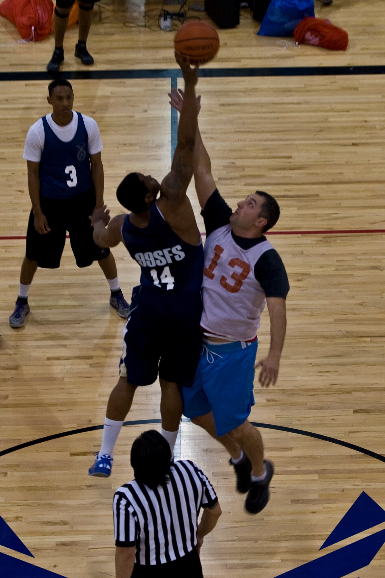 Airmen from the 99th Security Forces Squadron and 547th Intelligence Squadron jump for the ball during an intramural basketball game at the Warrior Fitness Center Feb. 3, 2014, at Nellis Air Force Base, Nev. Intramural basketball games are played weekly Monday through Thursday from 5:30 - 8:30 p.m. The 99th SFS won the game 60-49. With four weeks into the season, the 57th Aircraft Maintenance Squadron “Big Horn” is leading the East division while the 99th Civil Engineering Squadron leads the West division (U.S. Air Force photo by Senior Airman Christopher Tam)