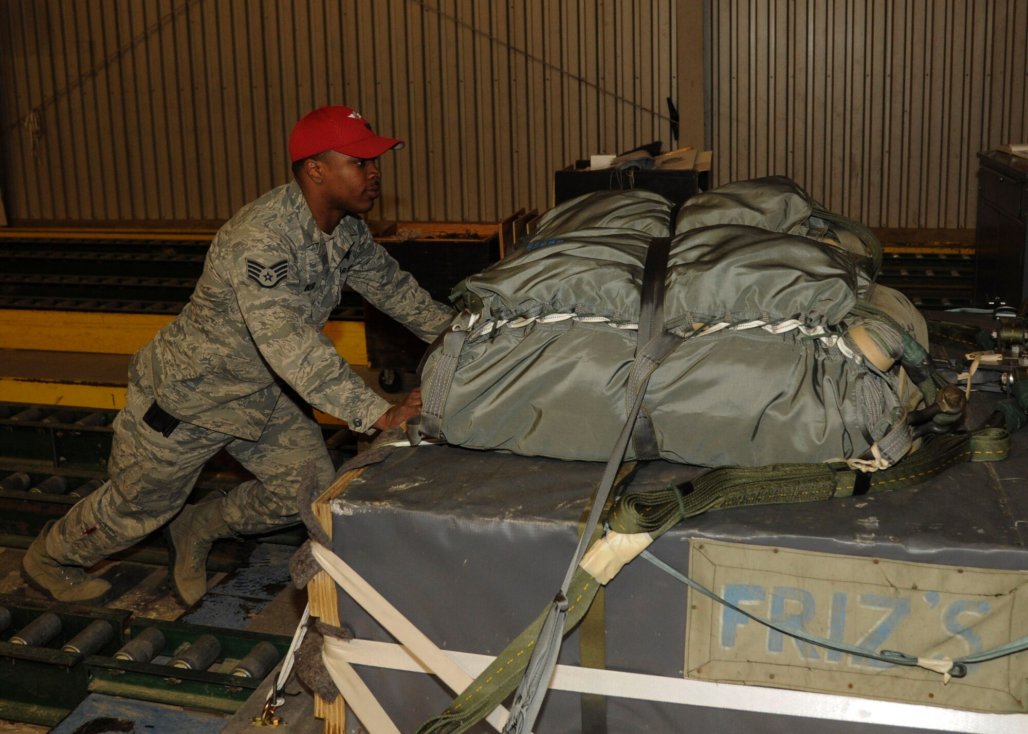 Staff Sgt. Victor Boyd, 19th Logistics Readiness Squadron aerial supervisor, pushes a prepared platform to be dropped from a C-130 Feb. 4, 2014, at Little Rock Air Force Base, Ark. When full, the pallets weigh more than 2,700 pounds. (U.S. Air Force photo by Airman 1st Class Harry Brexel) )