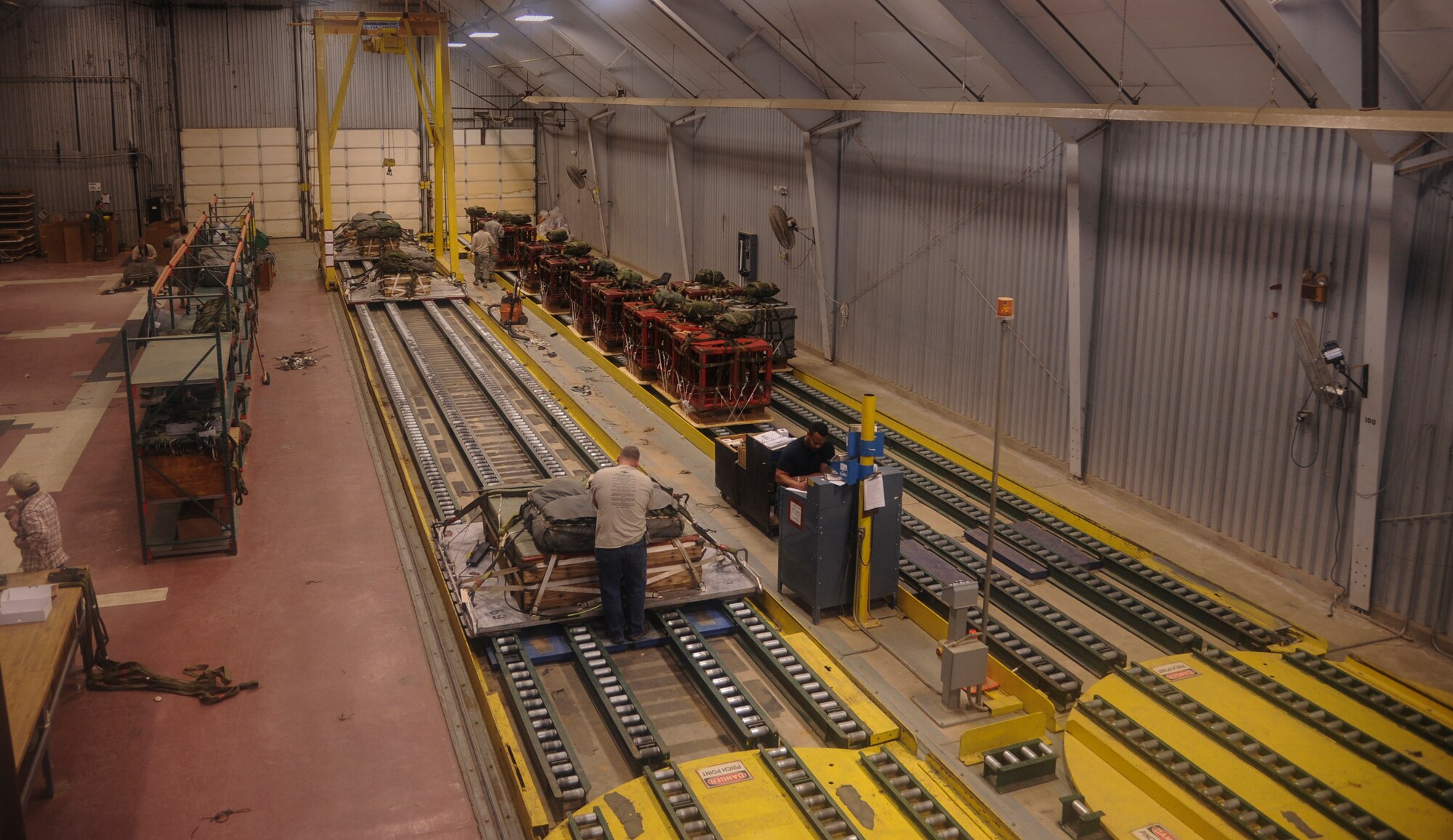 Civilians and Airmen work together at the 19th Airlift Wing’s Aerial Delivery shop Feb. 4, 2014, at Little Rock Air Force Base, Ark. The riggers work throughout the day preparing platforms for descent from The Rock’s C-130s. (U.S. Air Force photo by Airman 1st Class Harry Brexel)