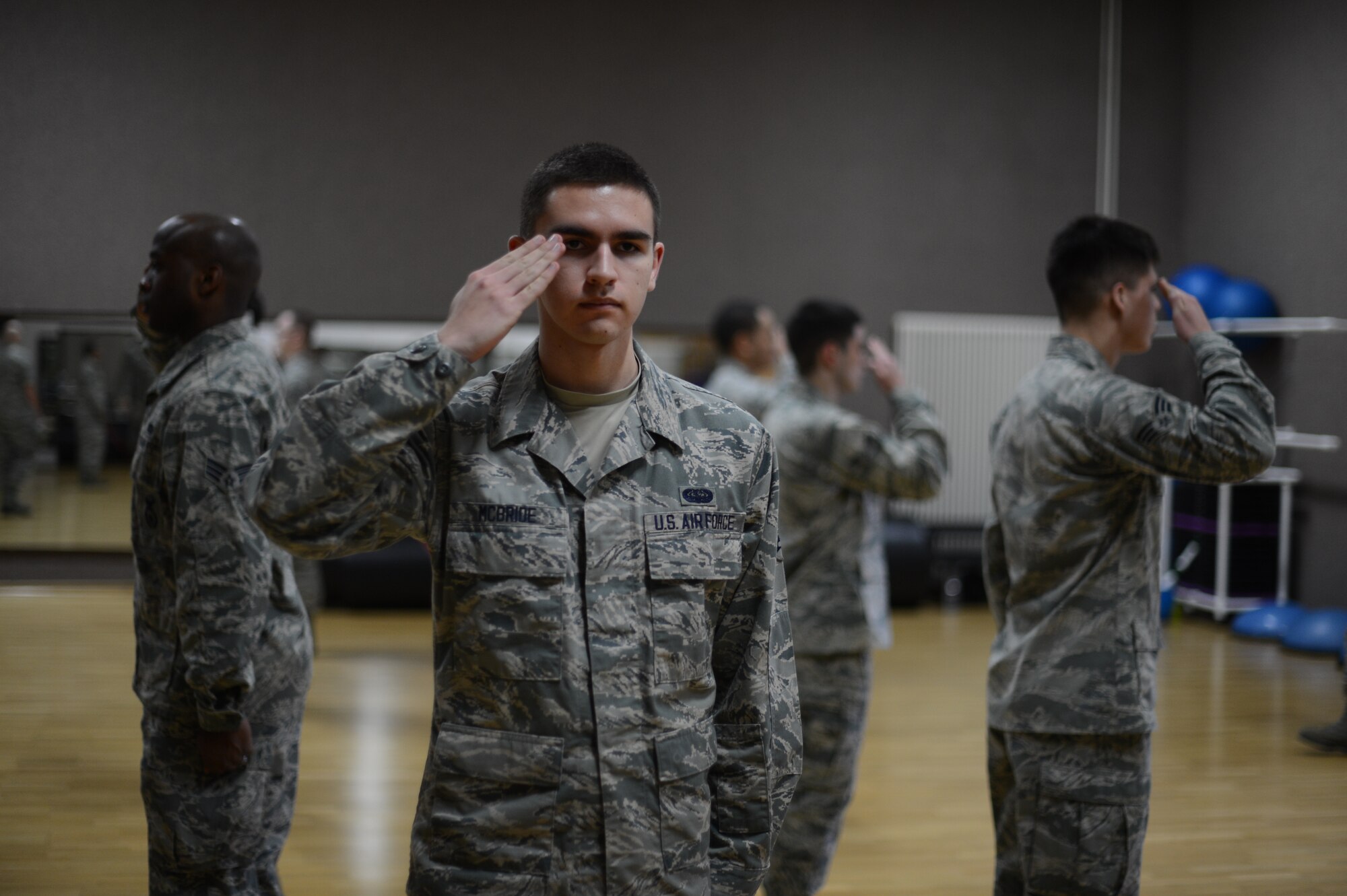 U.S. Air Force Airman 1st Class Michael McBride, 606th Air Control Squadron data maintenance technician from Orlando, Fla., practices saluting with his fellow airmen during an honor guard training week at Spangdahlem Air Base, Jan. 27, 2014. The trainees practiced for more than 40 hours to ensure their techniques and military bearing are at the highest level possible. (U.S. Air Force photo by Senior Airman Gustavo Castillo/Released)