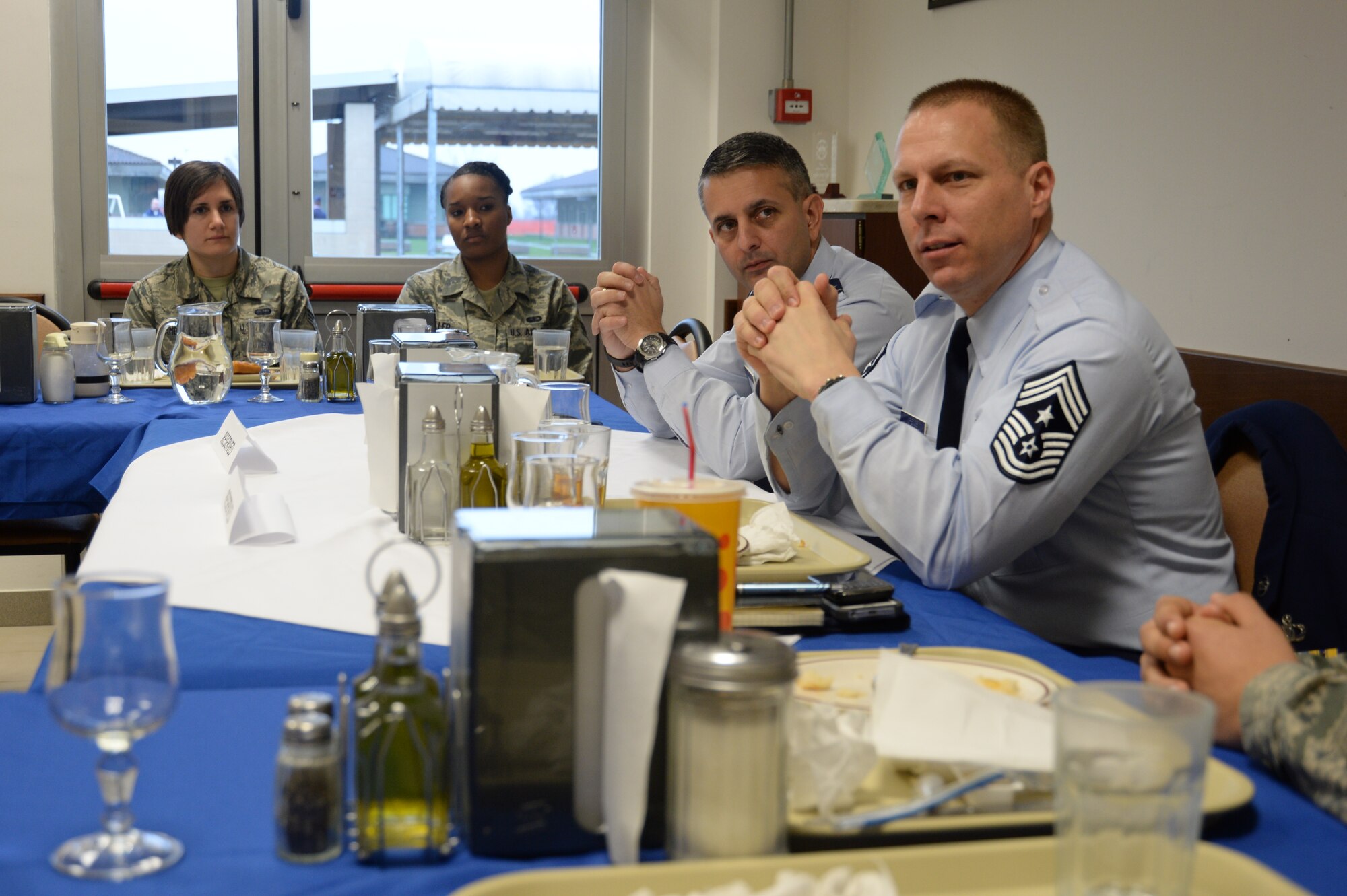 U.S. Air Force Col. David Julazadeh, 52nd Fighter Wing commander, center right, listens as Chief Master Sgt. Matthew Grengs, 52nd FW command chief, right, speaks to Airmen during a lunch at the Centurion dining facility at Ghedi Air Base, Italy, Jan. 31, 2014. Both wing leaders visited Airmen assigned to the 704th Munitions Support Squadron stationed on the Italian Air Force air base. (U.S. Air Force photo by Staff Sgt. Joe W. McFadden / Released)