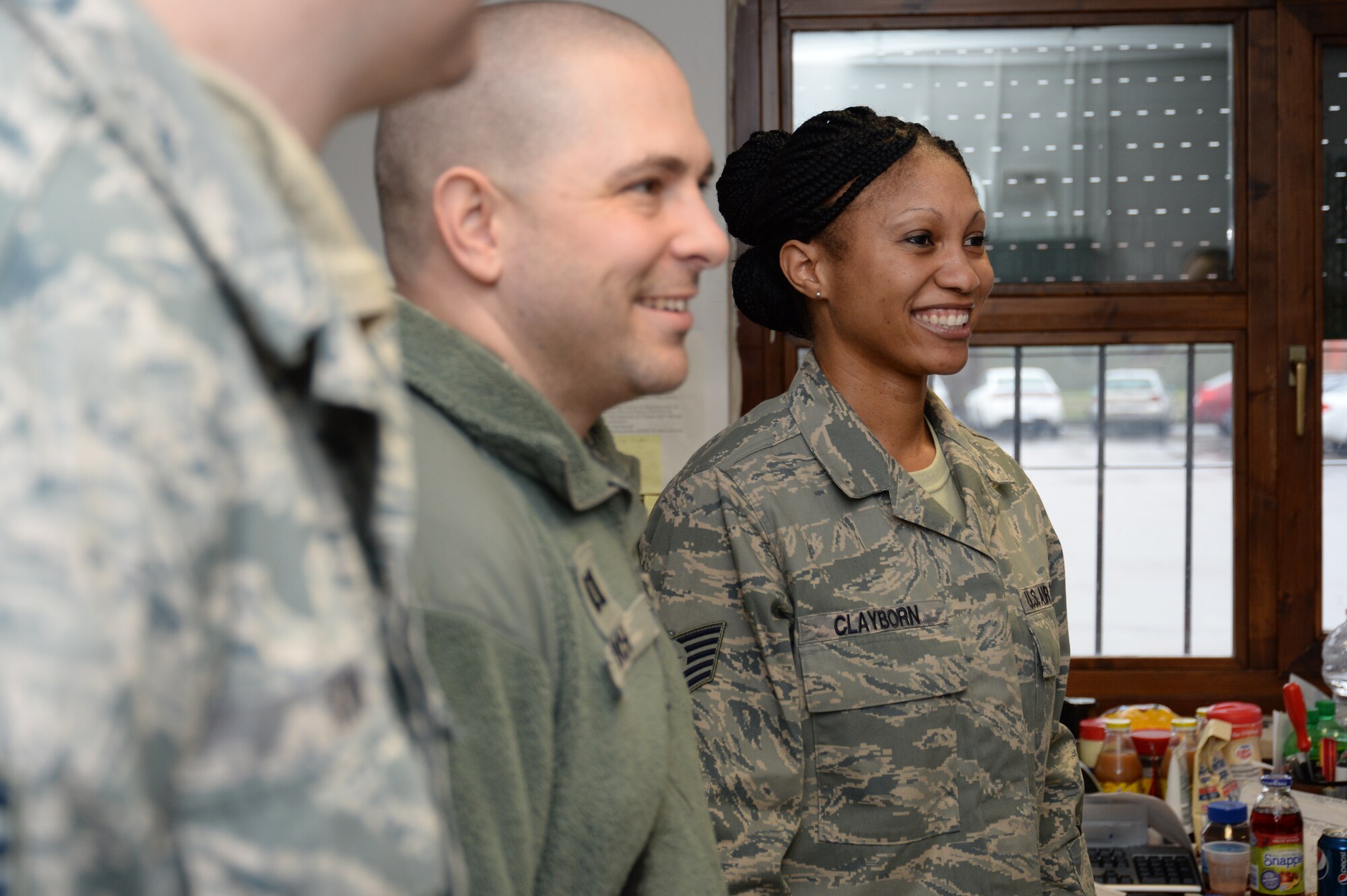U.S. Air Force Tech Sgt. Angelina Clayborn, 704th MUNSS postmaster and Jennings, Fla., native, right, listens as Chief Master Sgt. Matthew Grengs, 52nd Fighter Wing command chief, speaks to her office during a tour of Ghedi Air Base, Italy, Jan. 30, 2014. Clayborn received a chief's coin for her role in creating the base's Airmen Against Drunk Driving program. (U.S. Air Force photo by Staff Sgt. Joe W. McFadden / Released)