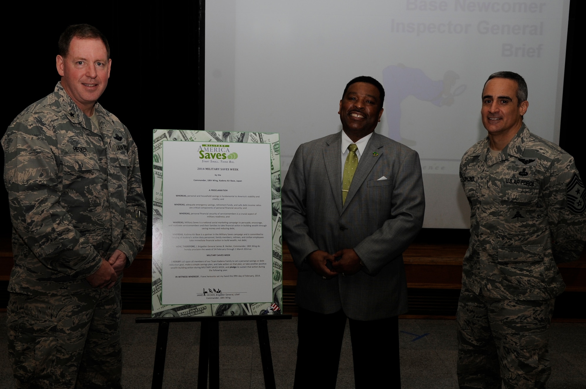 U.S. Air Force Brig. Gen. James Hecker, 18th Wing commander, poses with Charles Howard, 18th Force Support Squadron community readiness consultant, and Chief Master Sgt. Ramon Colon-Lopez, 18th Wing command chief, after signing a military savings proclamation on Kadena Air Base, Japan, Feb. 5, 2014. The proclamation declares Feb. 24 to March 1 Military Saves Week and calls upon the members of Kadena to set-up a savings plan and find ways to reduce debt. (U.S. Air Force photo by Senior Airman Marcus Morris)